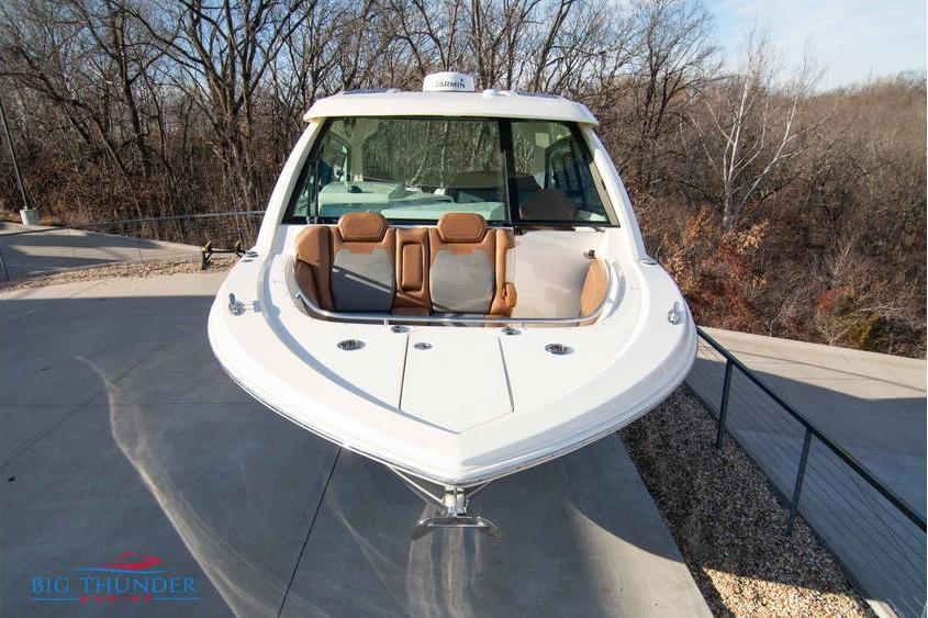 2022 Scout 350 LXZ boat with sleek design, docked outdoors in a wooded area.