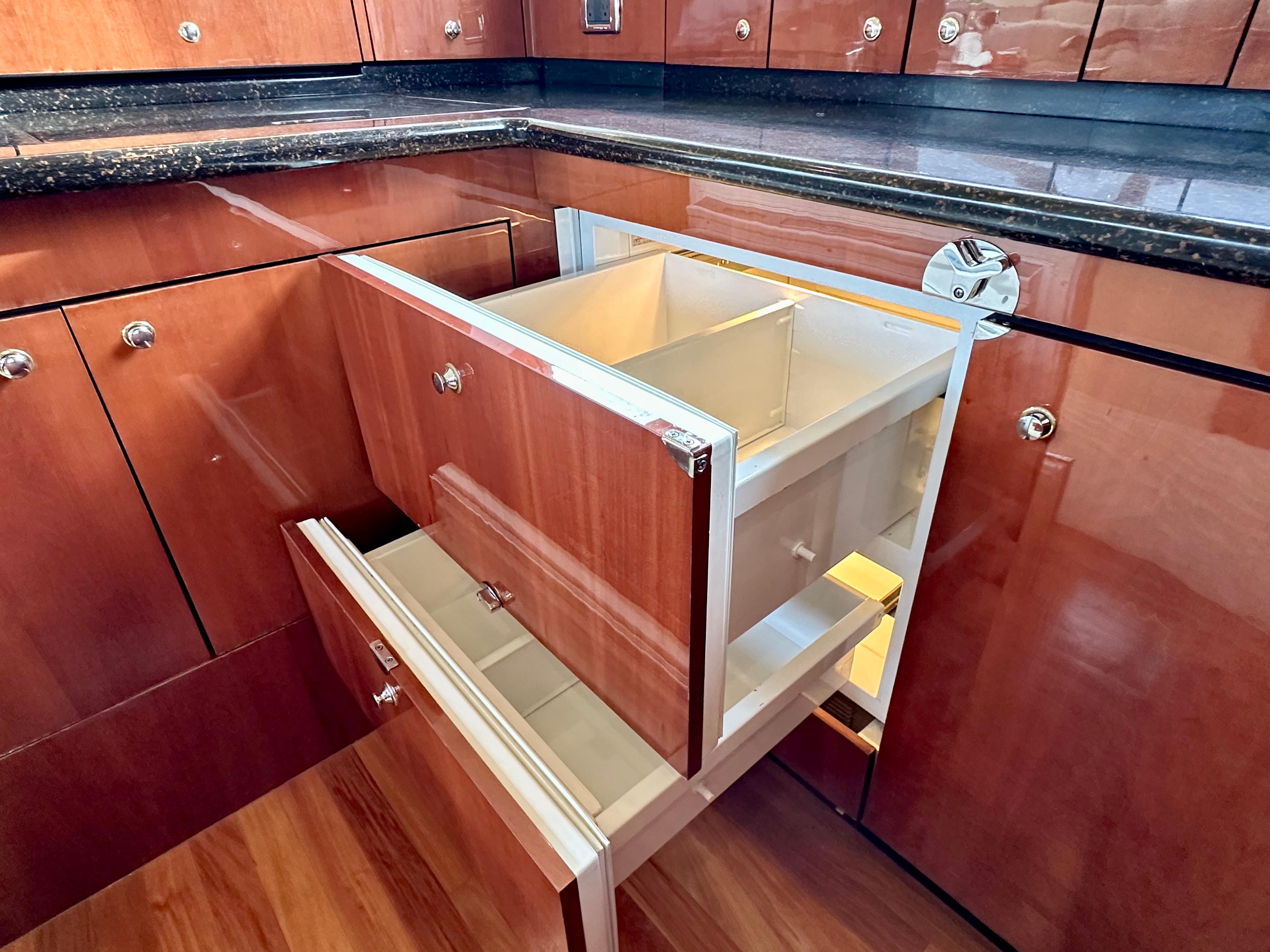 Luxurious wooden cabinetry with open drawers in a 2002 Sea Ray 560 Sedan Bridge yacht.