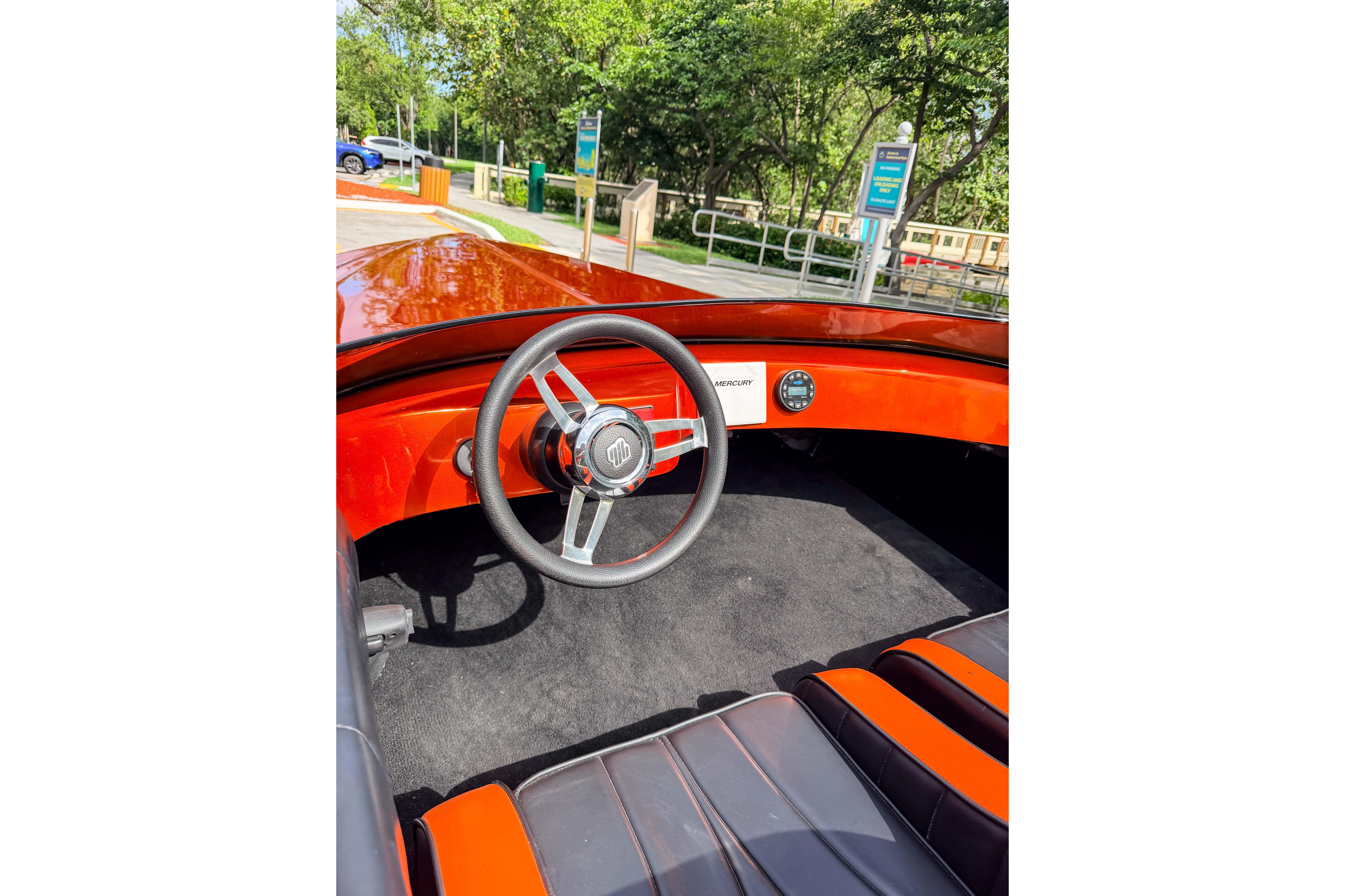 1984 Sleekcraft Aristocrat 20 boat interior with red dashboard and steering wheel.