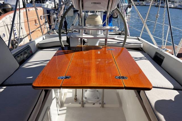 Cockpit of 1988 Hylas Custom 44 sailboat with polished wooden table and seating.