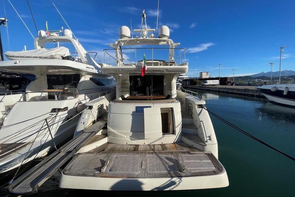 Luxury yacht Dominator 680, 2008 model, docked at marina under clear blue sky.