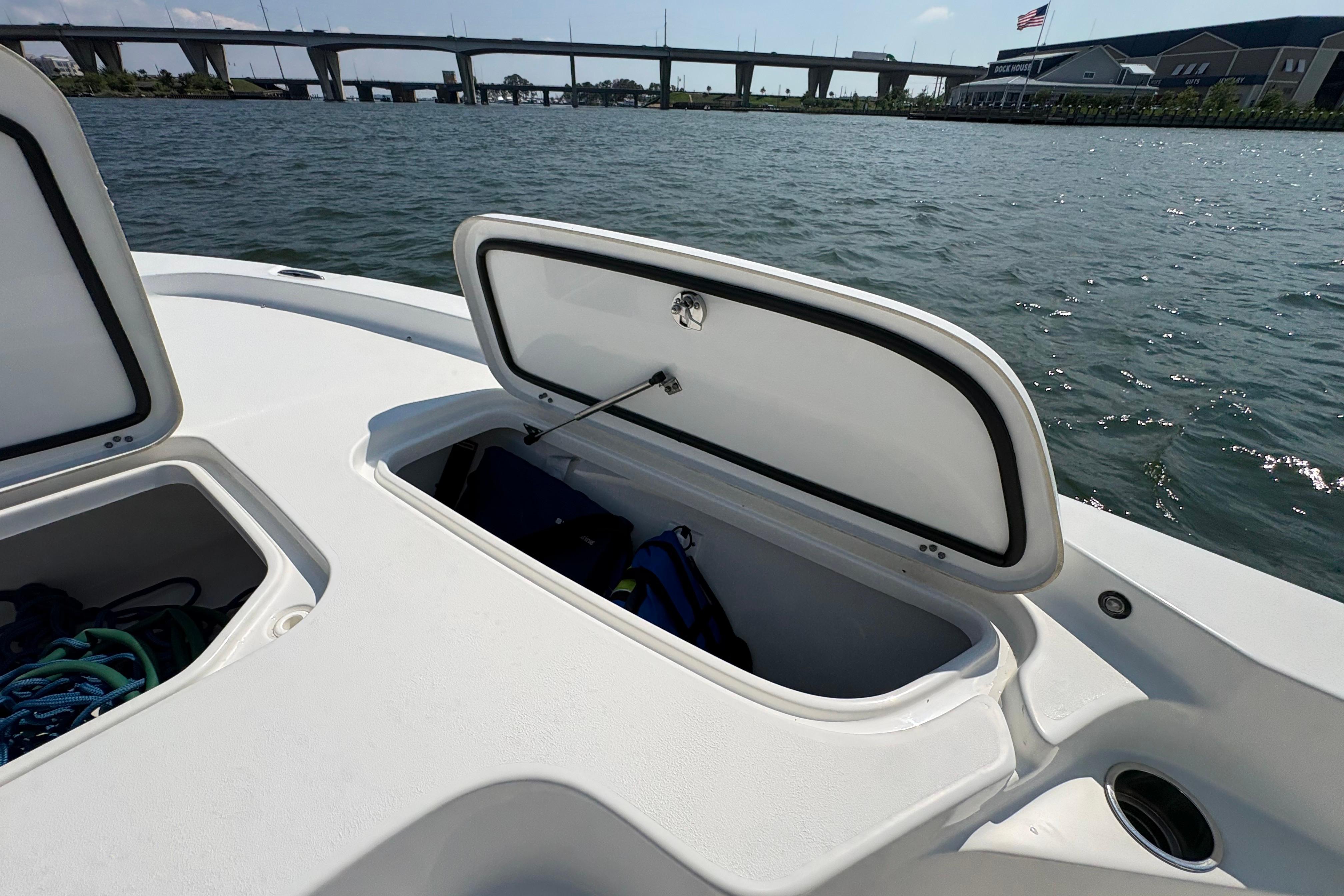 2017 Sea Hunt BX 25 BR boat with open storage compartments on a sunny day.