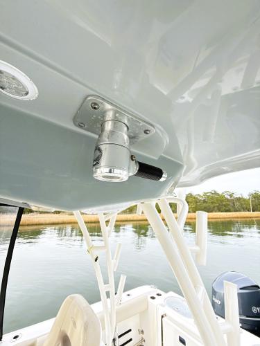 2016 Cobia 296 Center Console boat detail with rod holders and water view.