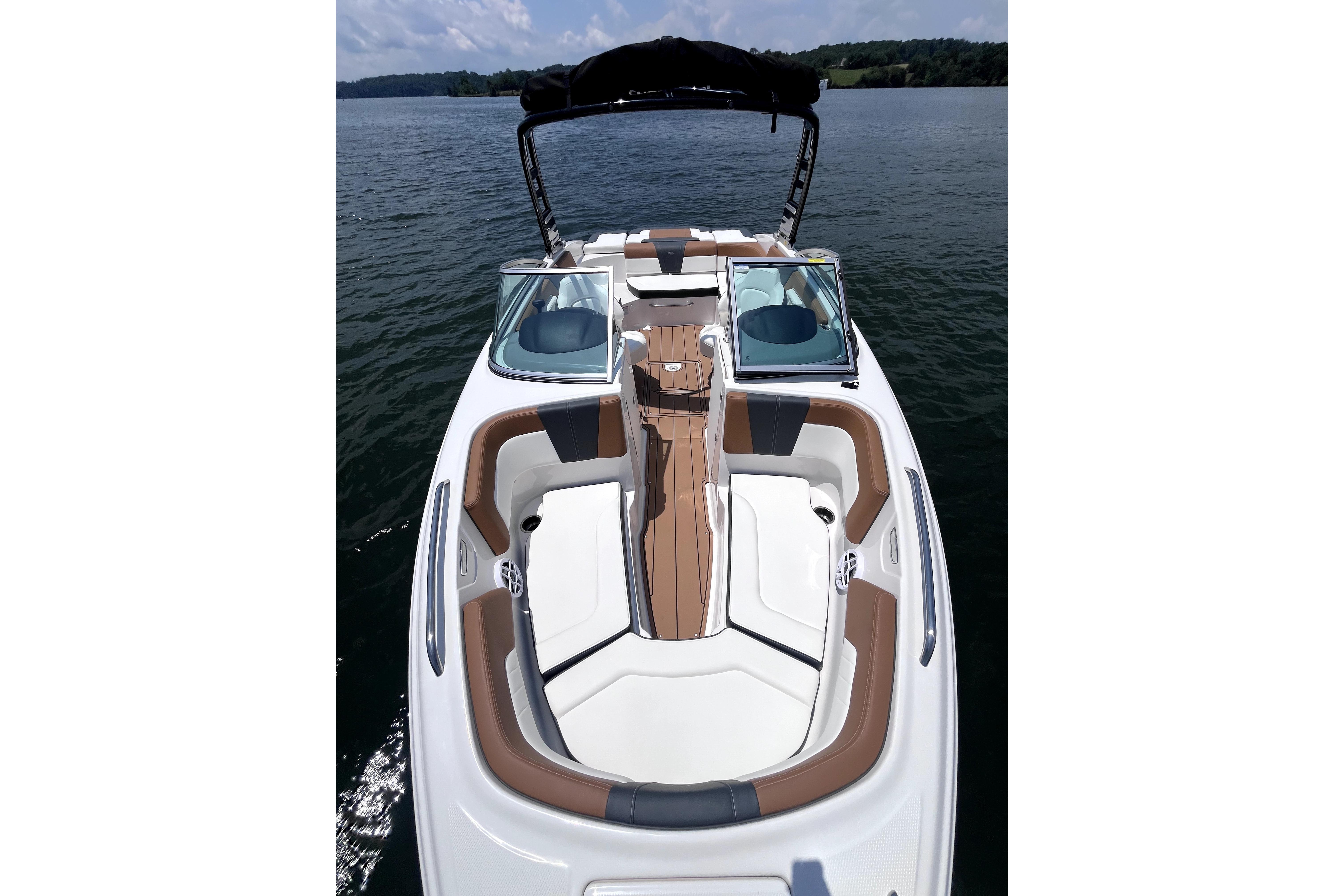 2025 Chaparral 230 SSi boat with sleek seating on a calm lake.