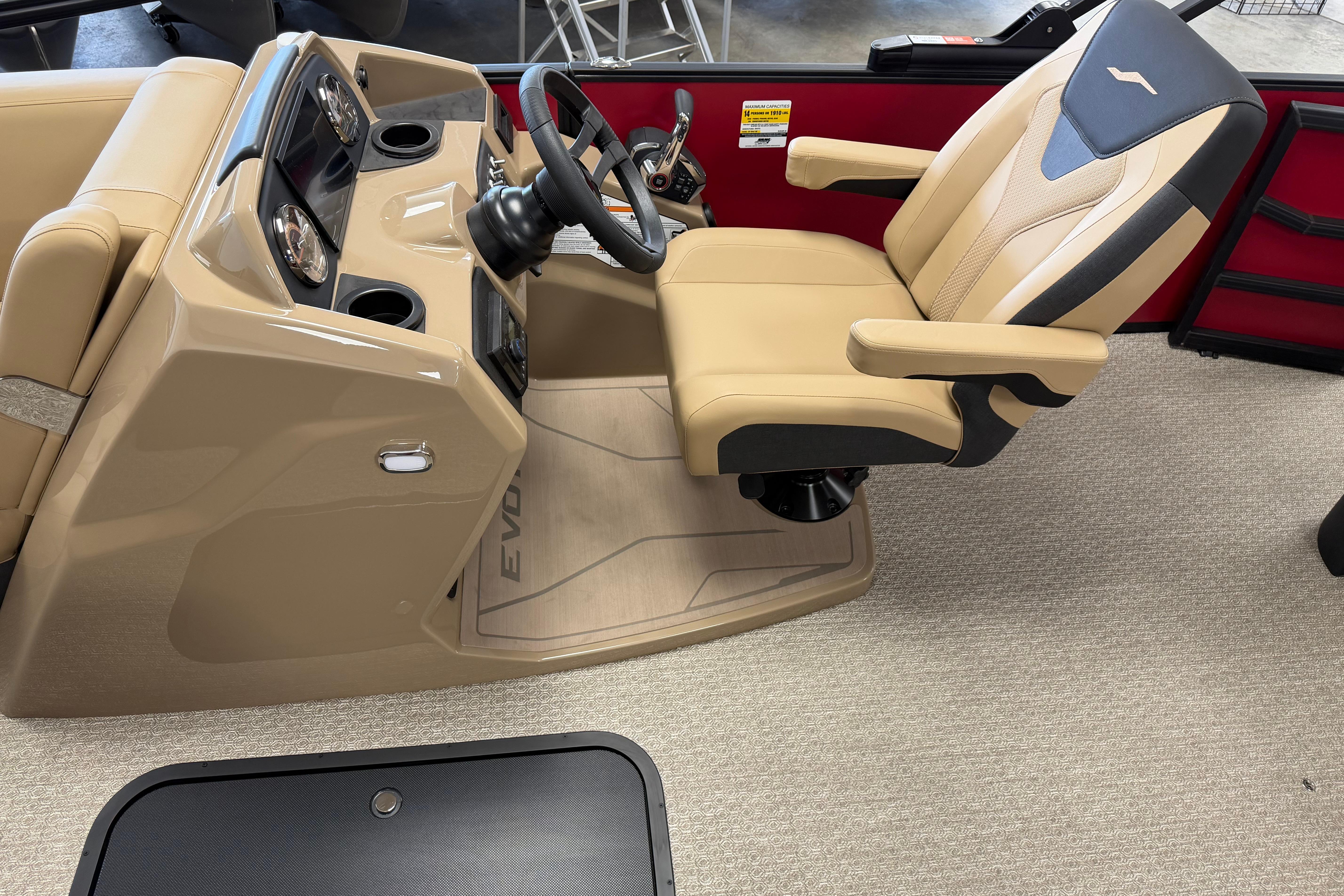 Captain's chair and dashboard of 2026 Evotti 523CS boat, featuring beige and black design.