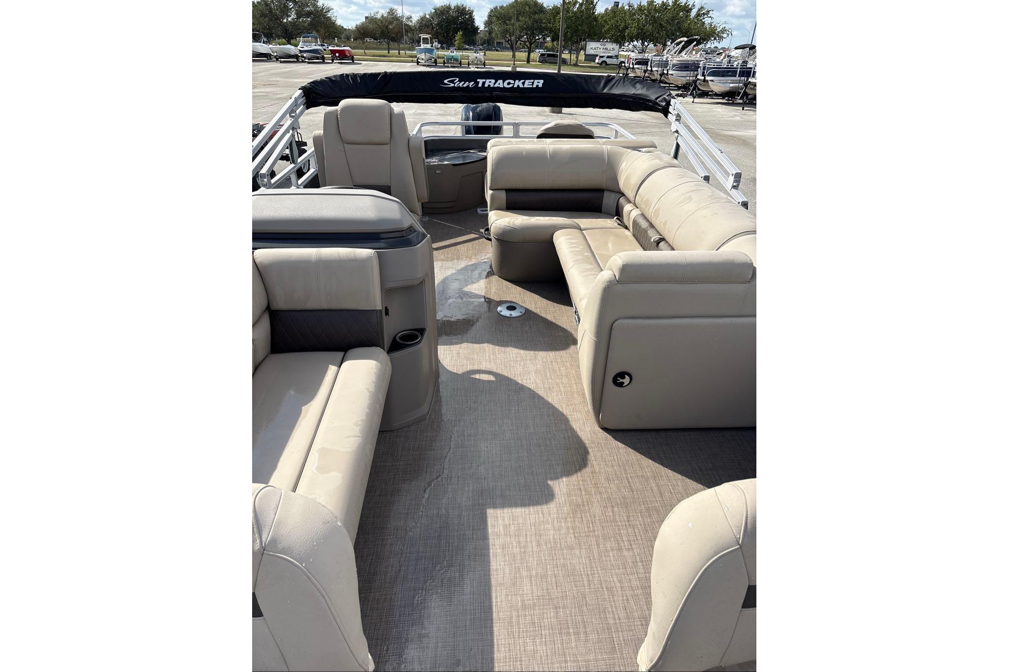 2025 Sun Tracker Fishin' Barge 20 DLX interior with beige seating and spacious layout.