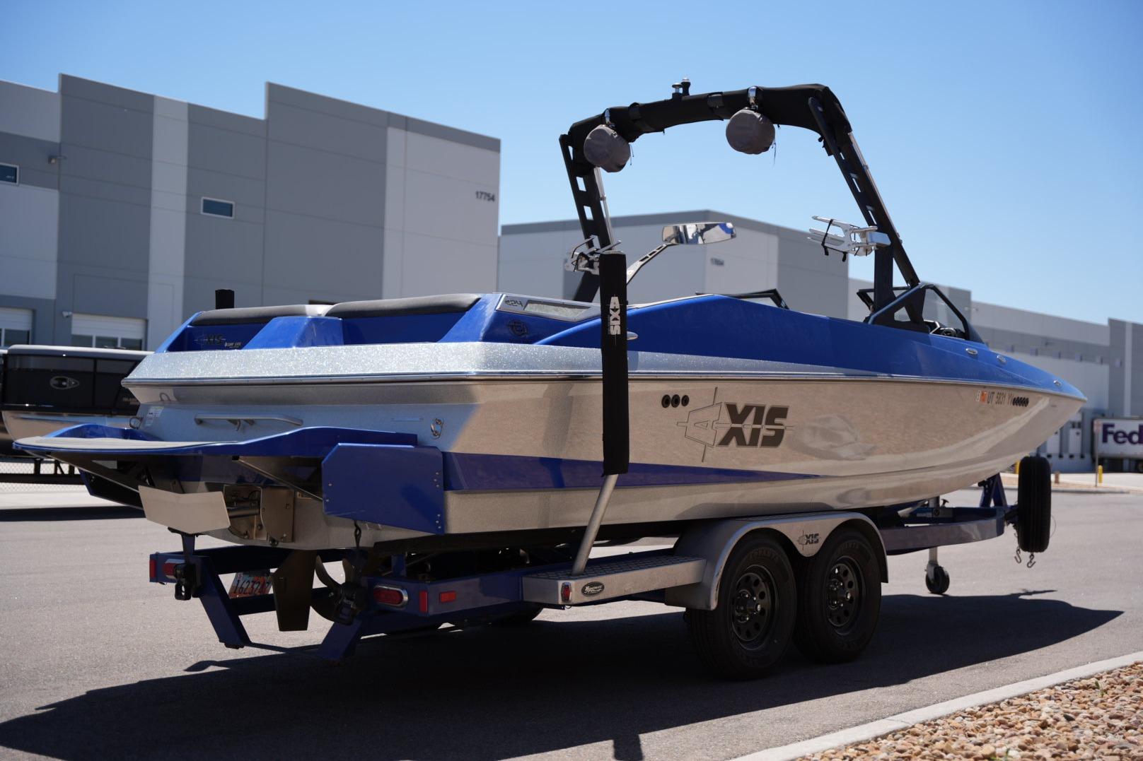 2015 Axis A24 boat on trailer, parked near industrial buildings.