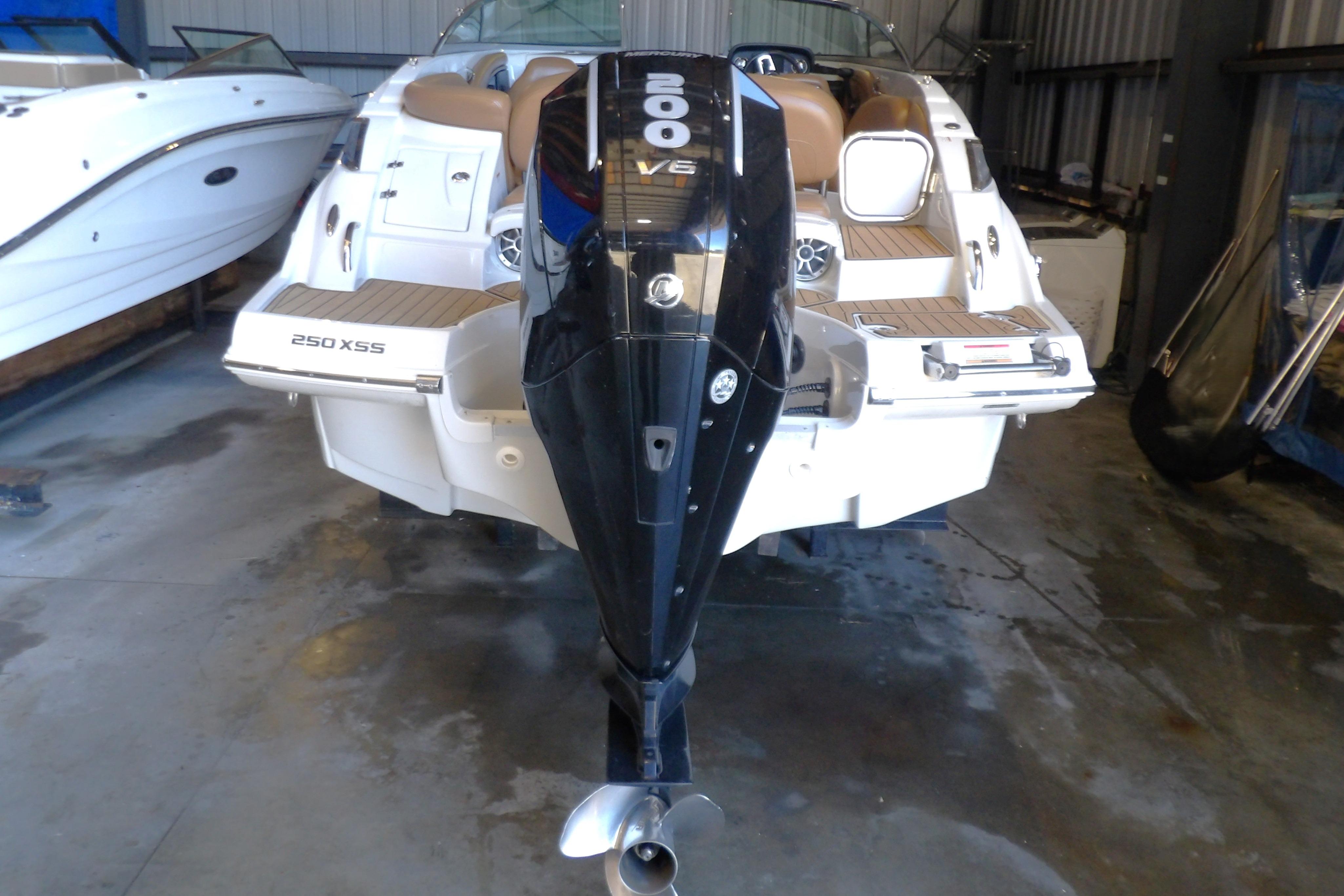 2023 Crownline 250 XSS boat with powerful outboard motor in storage facility.