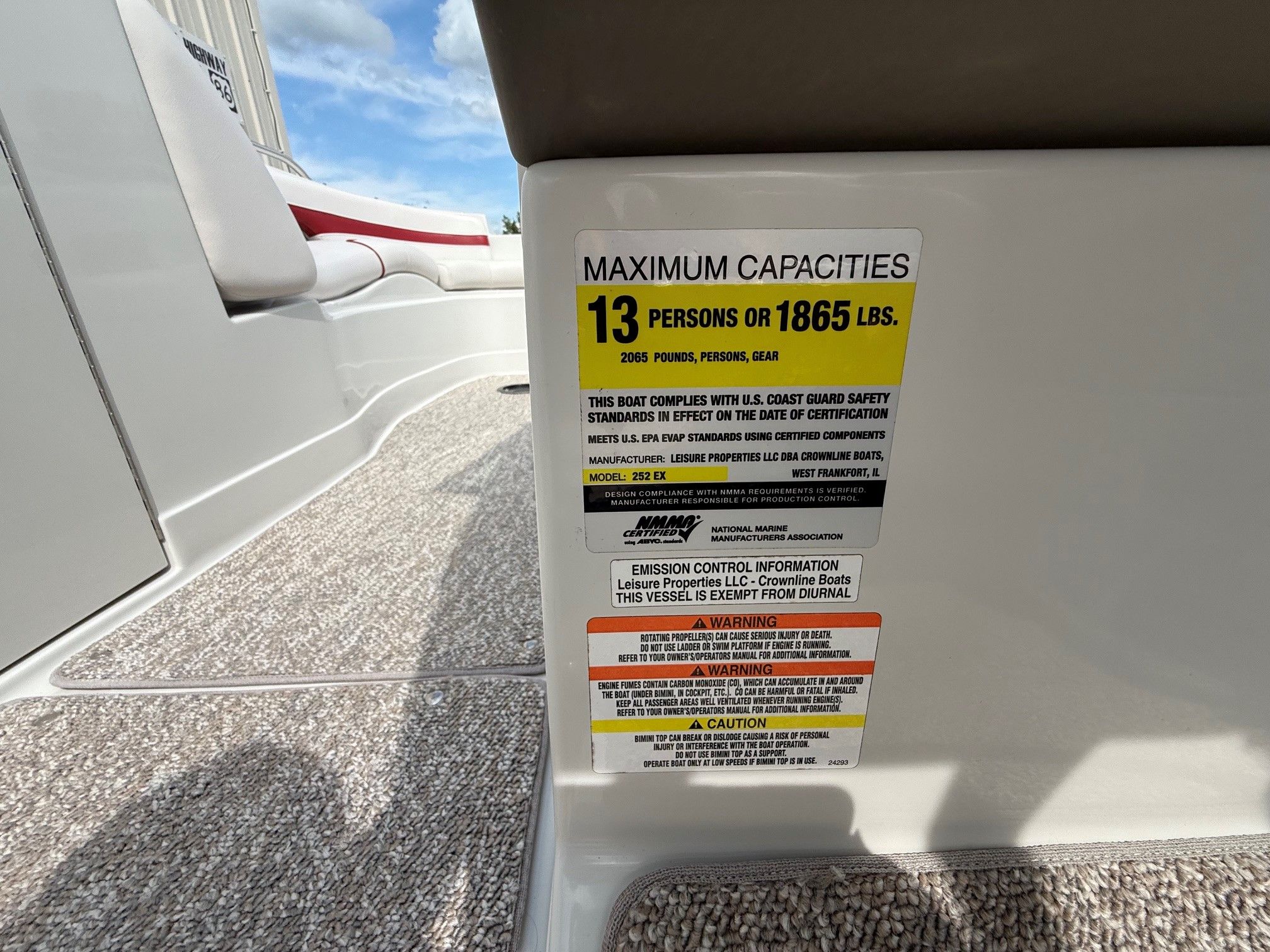 A sign on a boat shows the maximum capacity of 13 persons or 1865 pounds.