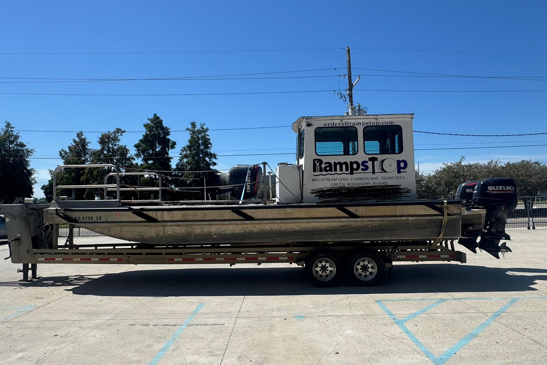 Custom Aluminum Work Boat 33, 2010 model, on trailer with Suzuki outboard motor.