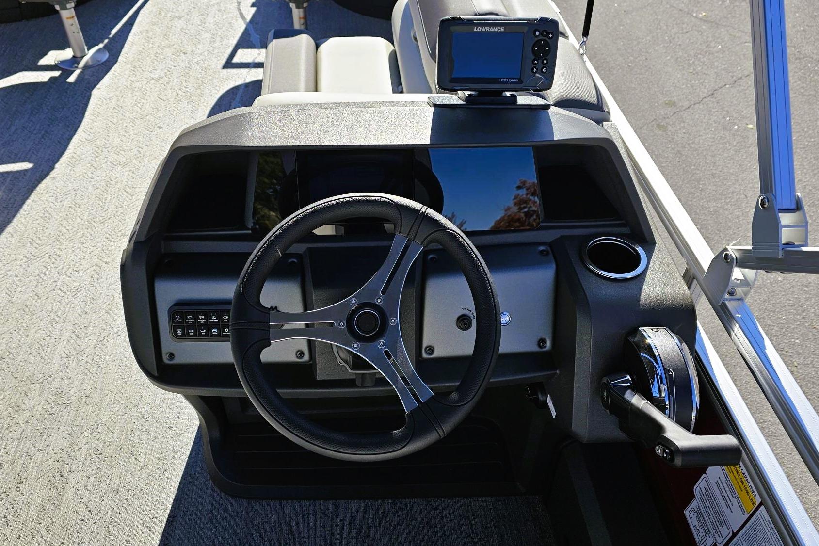 2026 Sun Tracker Fishin' Barge 22 DLX dashboard with steering wheel and navigation system.