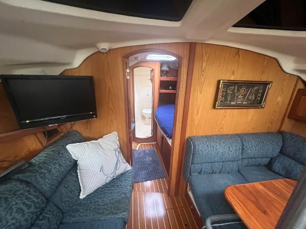 Interior of a 2000 Hunter 410 with cozy seating and a television.