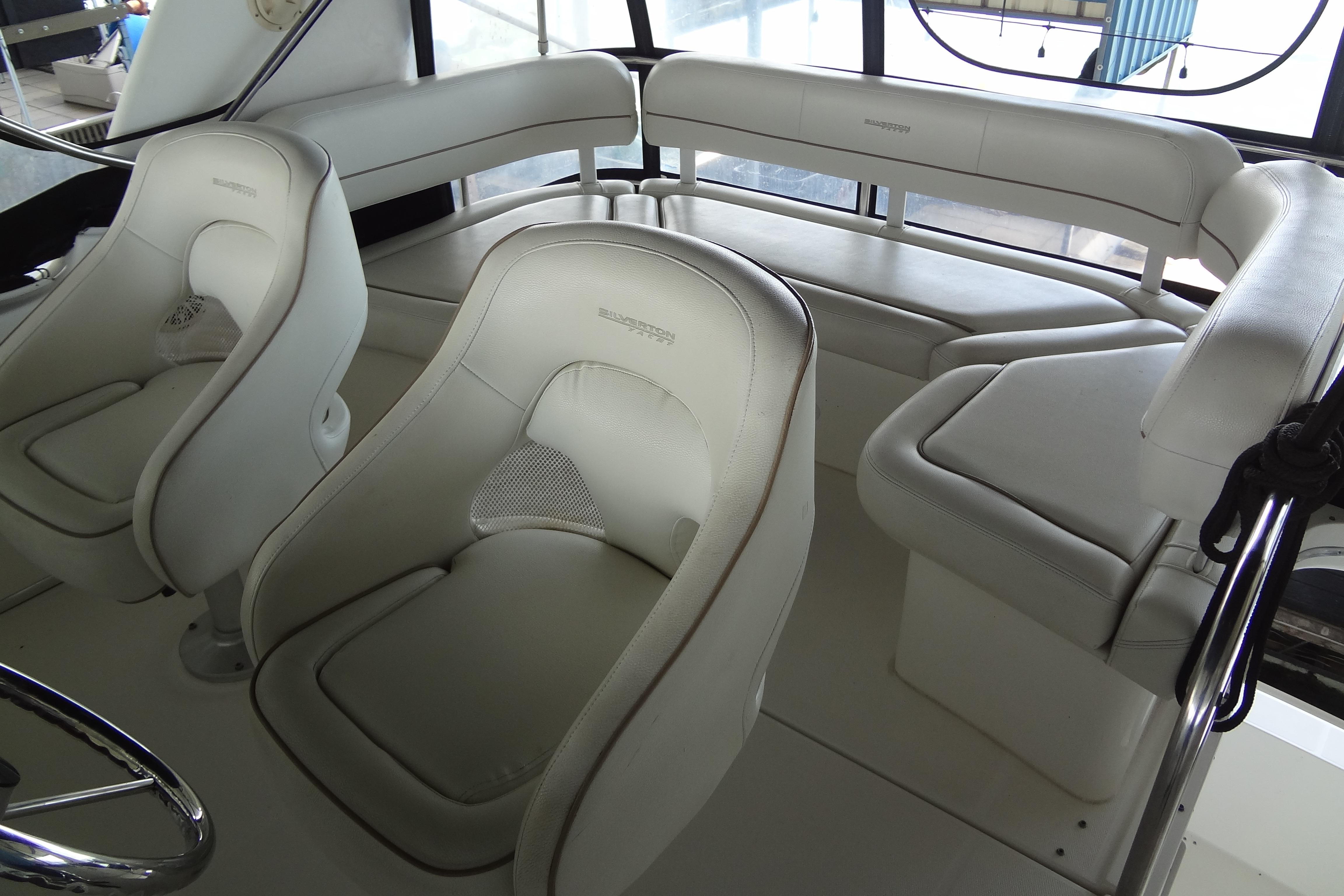 Interior seating of 2005 Silverton 34 Convertible yacht, featuring white cushioned seats.