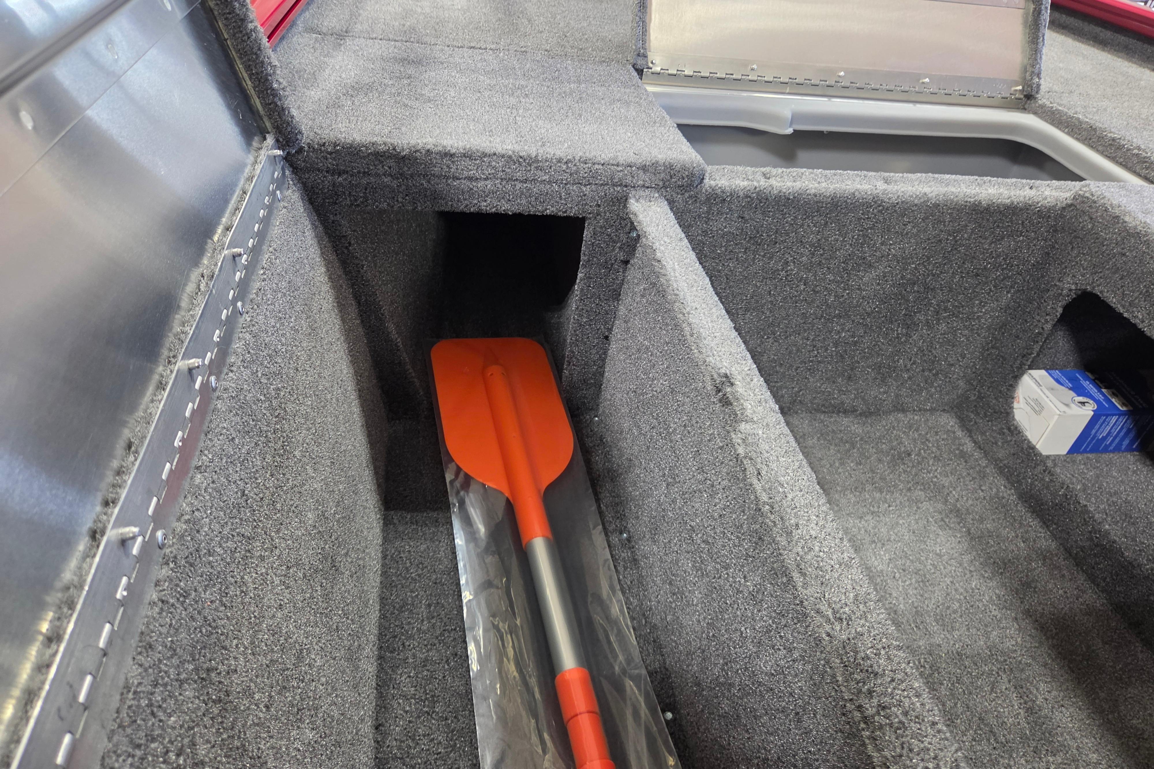 Interior of 2026 Tracker Pro 170 boat with storage compartments and an orange paddle.