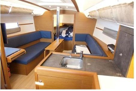Interior of 2023 Jeanneau Sun Odyssey 349 Performance sailboat, featuring modern seating and kitchenette.