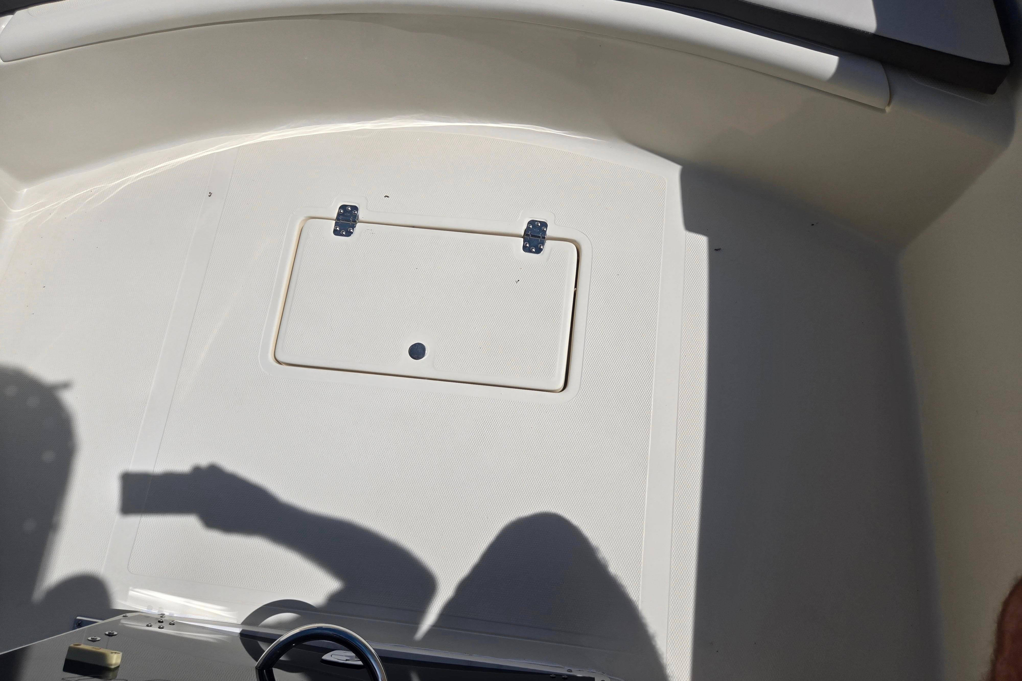 2016 Key Largo 2000CC boat deck with storage hatch and steering wheel shadow.