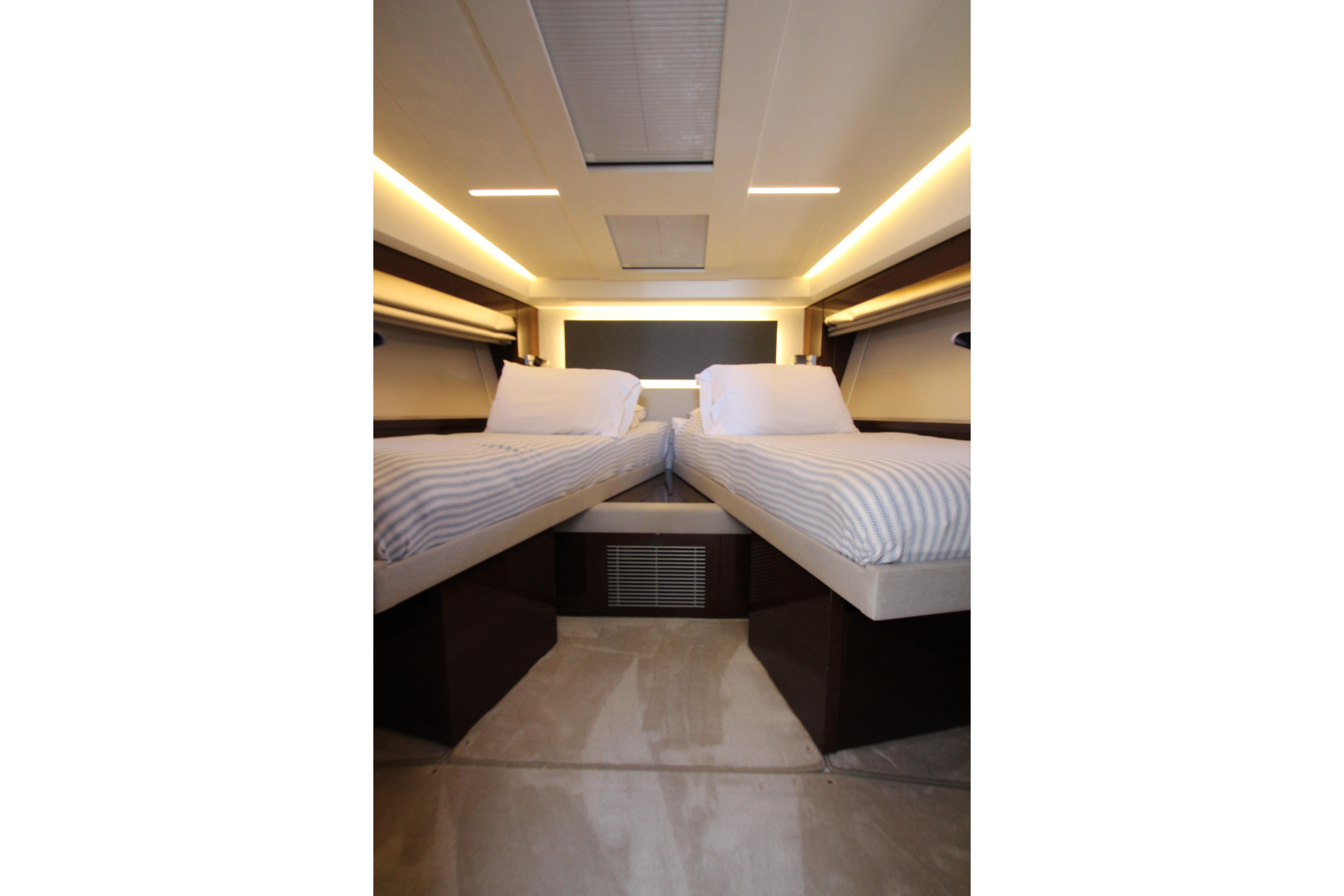 Luxurious twin cabin interior of 2022 Prestige 520 yacht, featuring modern design and ambient lighting.