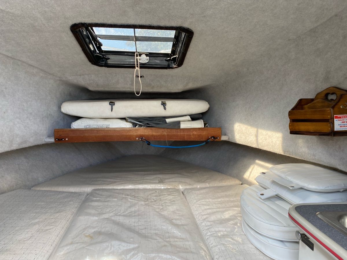 Interior of 1990 Bayliner 2302 Trophy with sleeping area and storage.