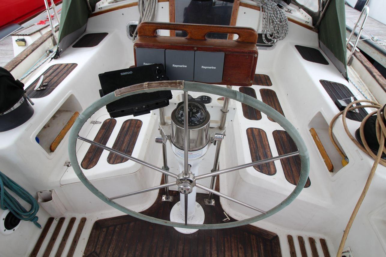Cockpit of 1985 Passport 47 sailboat with steering wheel and navigation equipment.