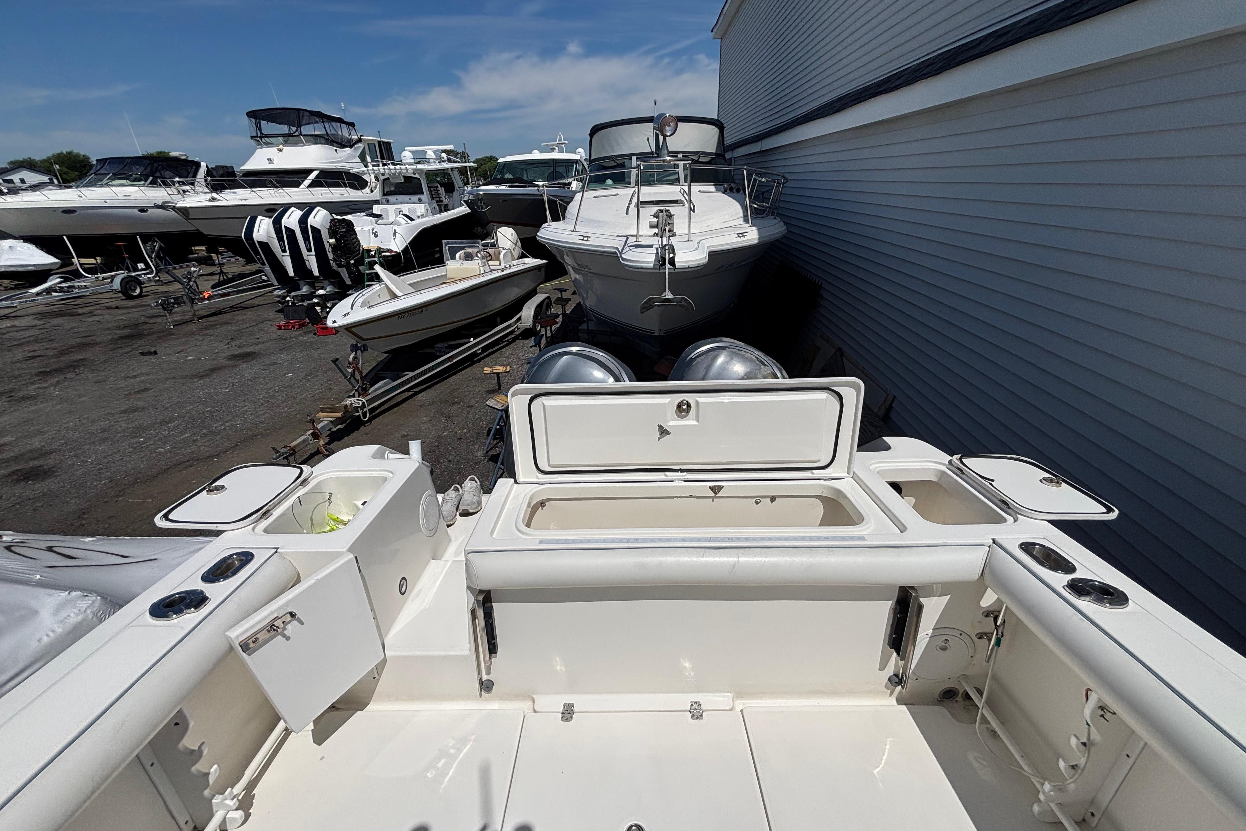2006 Edgewater 318CC boat in marina, surrounded by other vessels, under clear blue sky.