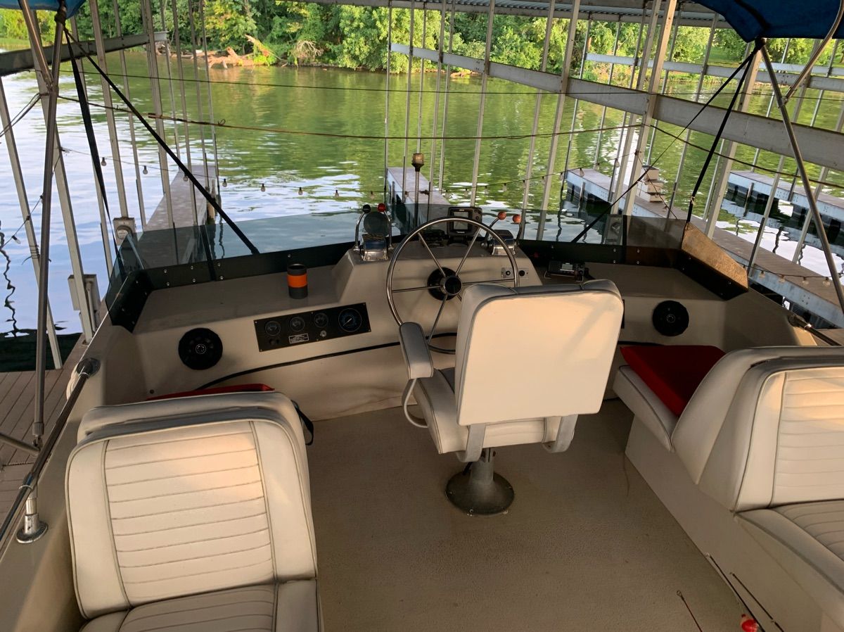 The image shows a boat's cockpit with white seats and a steering wheel.