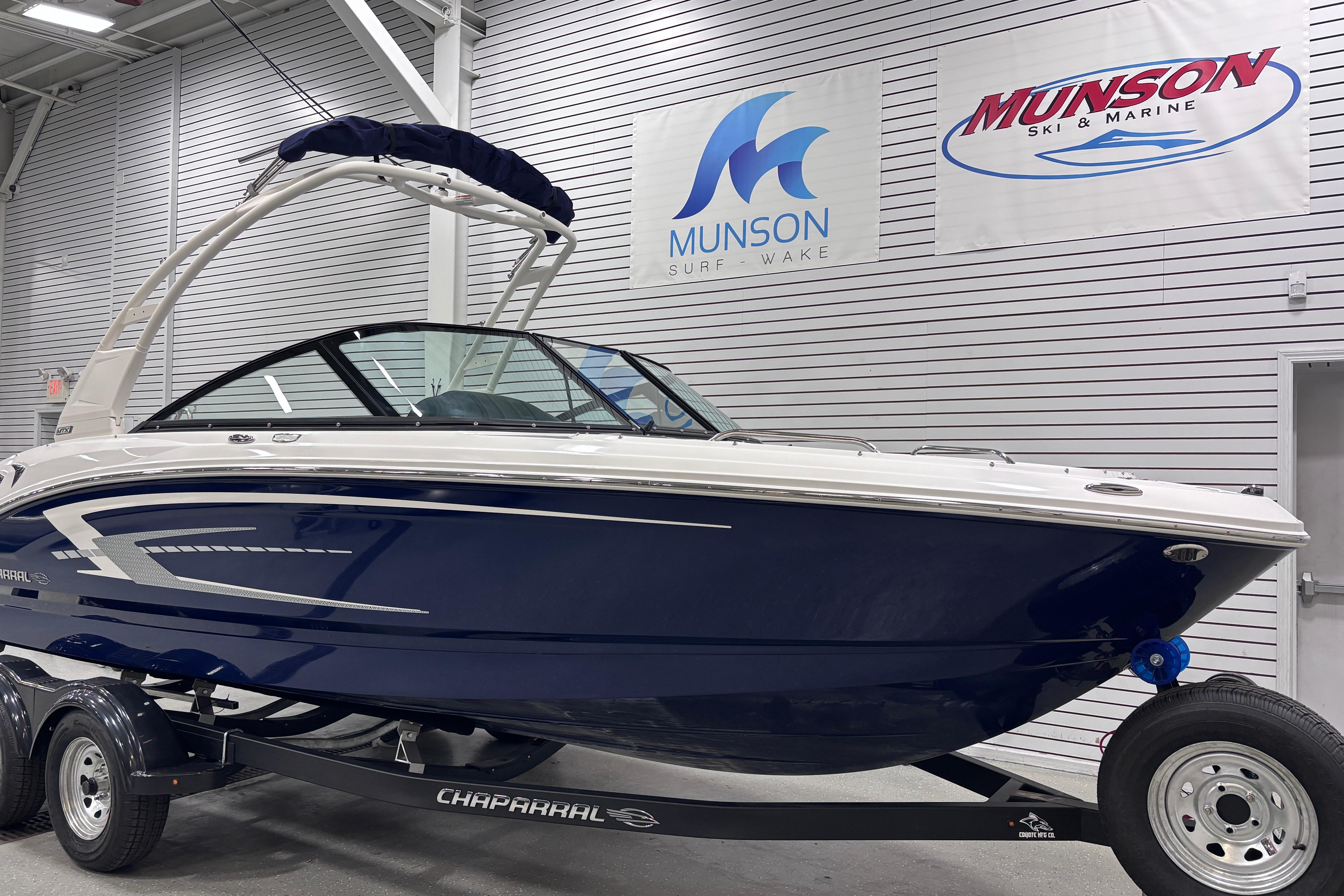2026 Chaparral 21 SSi boat in showroom, blue and white design, on trailer.