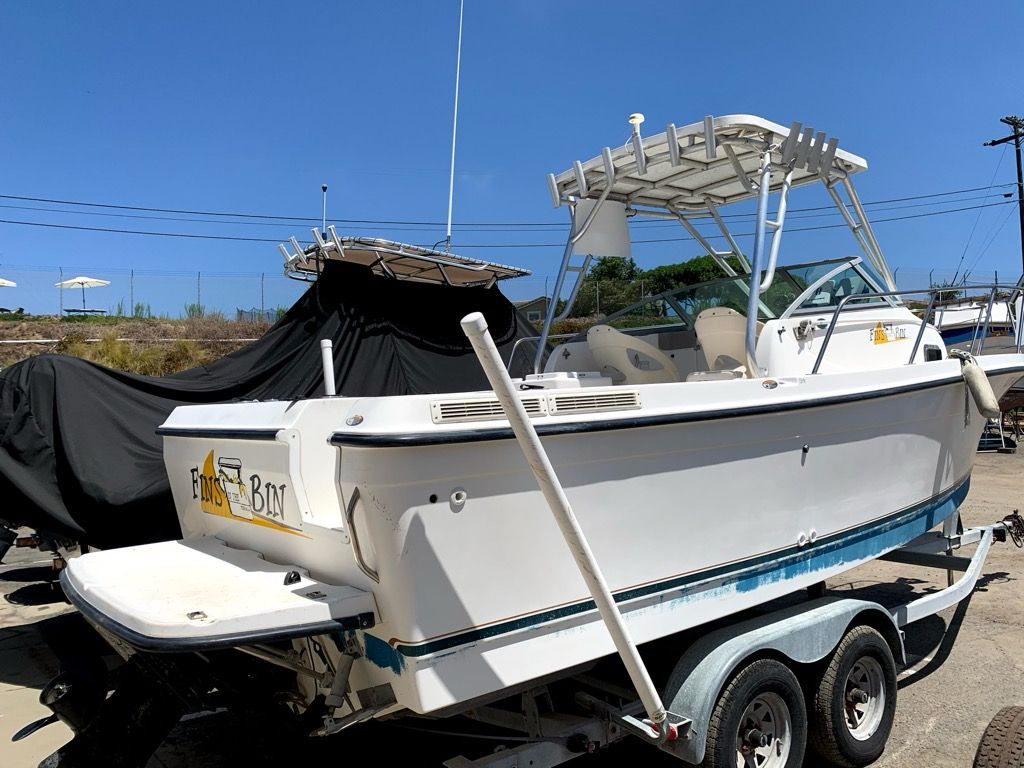 A 2003 Bayliner Walk Around Cuddy Cabin boat on a trailer under a blue sky.