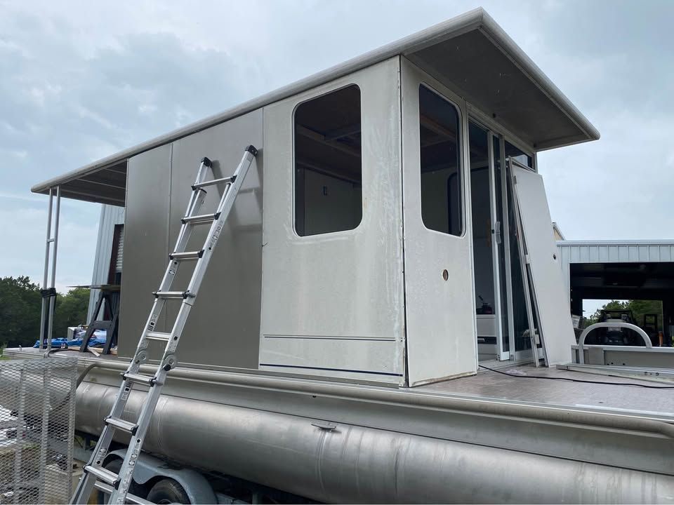 2008 Sun Tracker Party Cruiser with ladder and covered area.