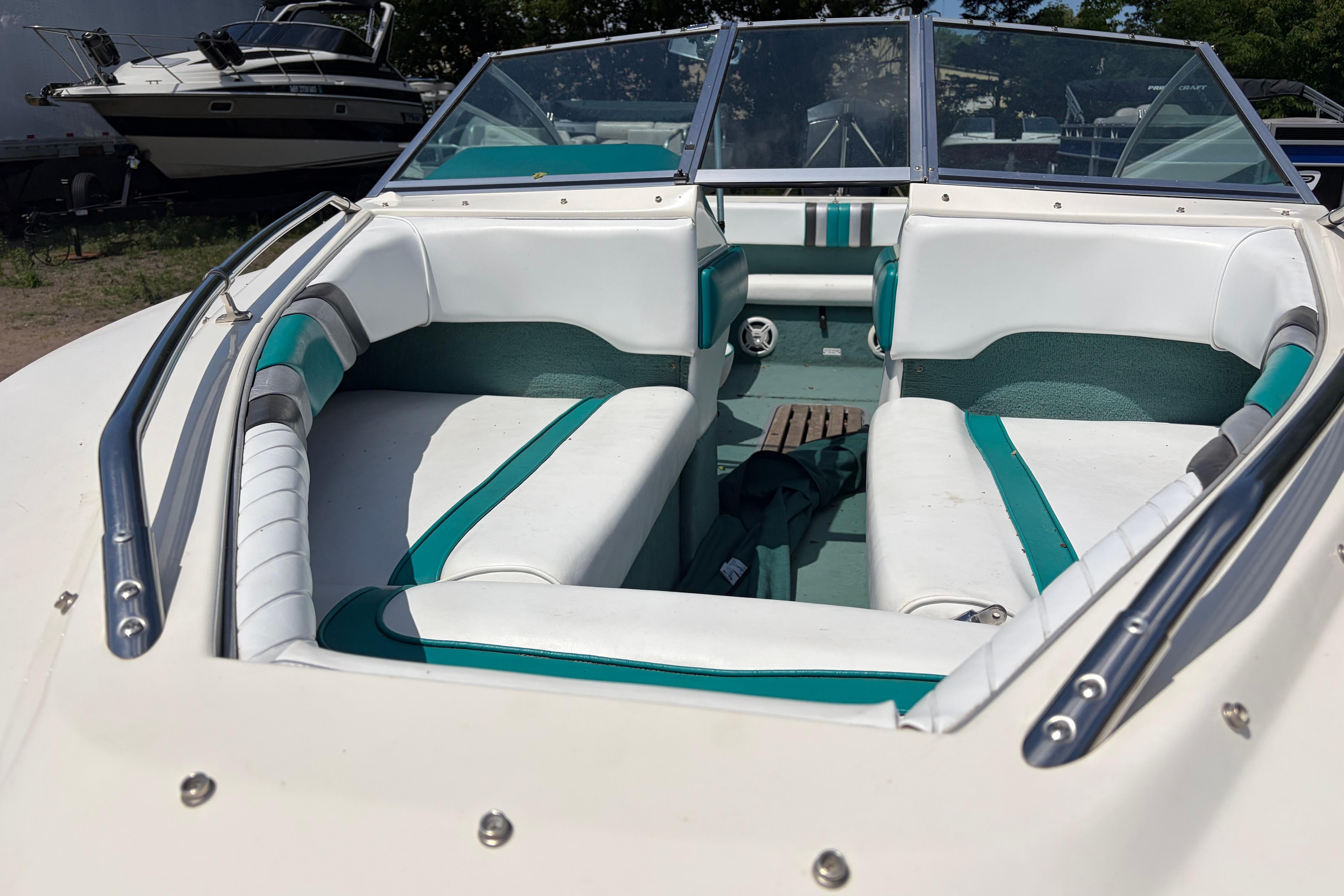 1990 Sea Ray 180 Bow Rider interior with white and teal seating, open bow design.