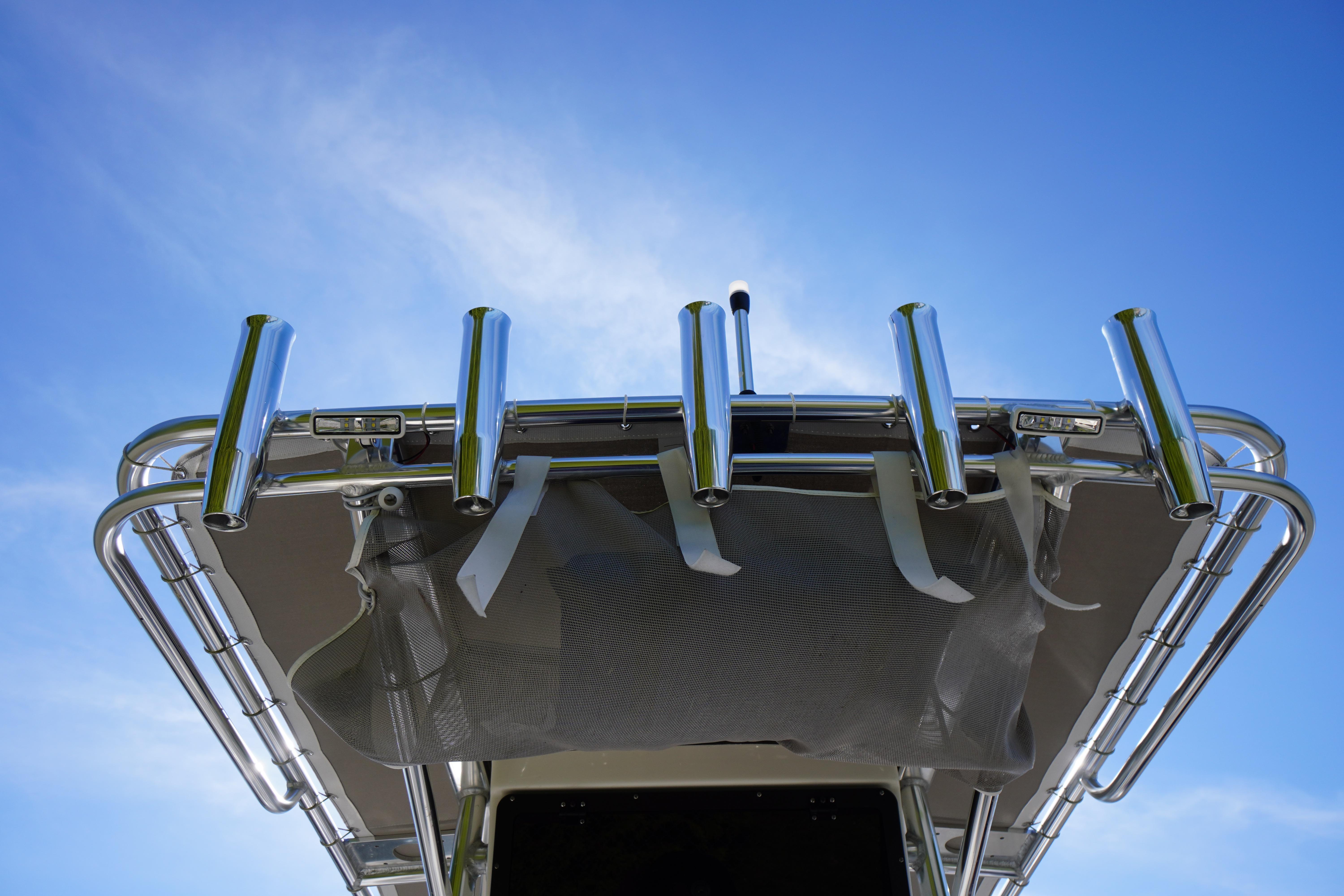 2025 Key West 203 FS boat with rod holders against a clear blue sky.