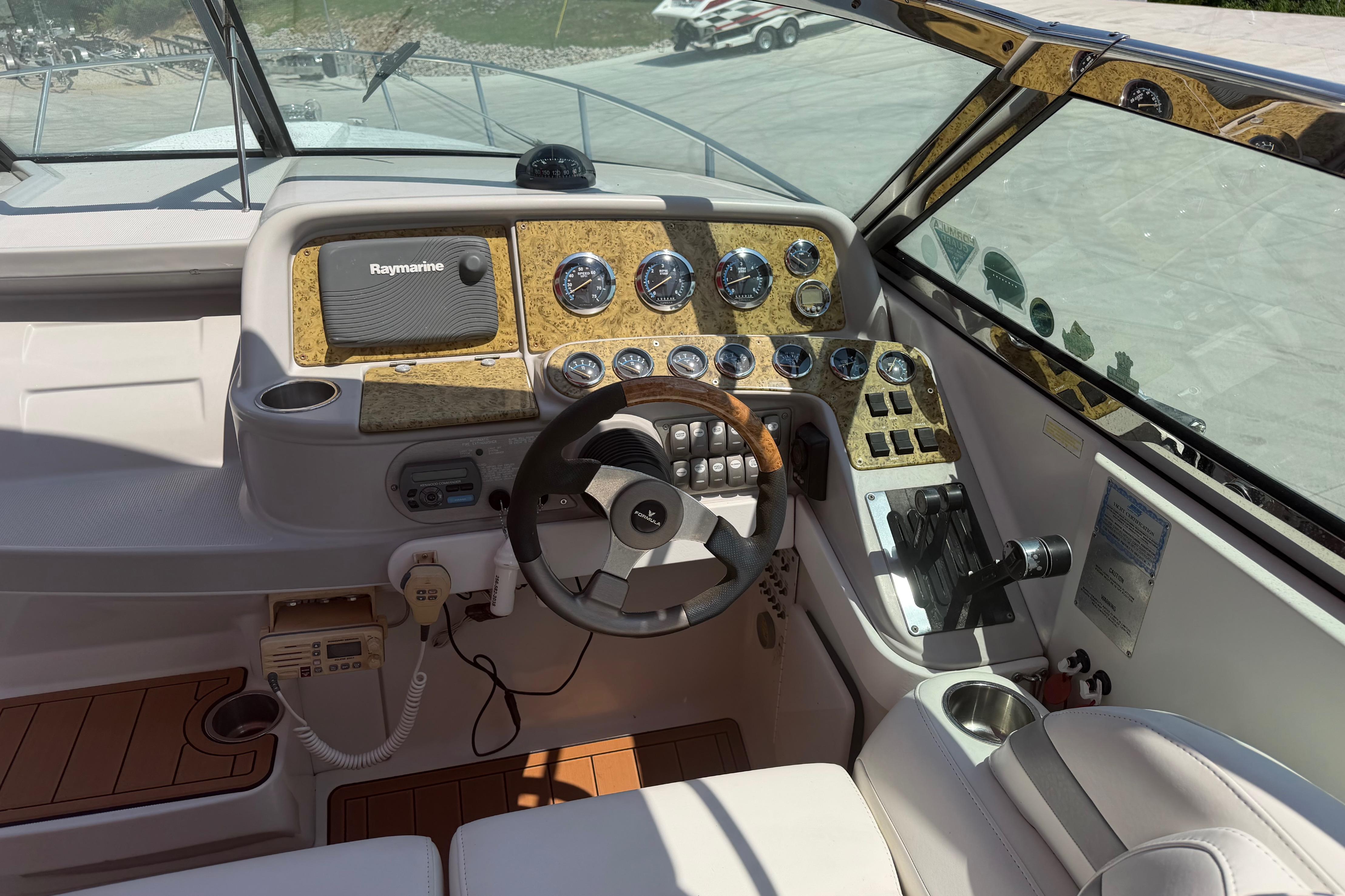 Cockpit of 2006 Formula 330 Sun Sport with Raymarine navigation and wood-accented dashboard.
