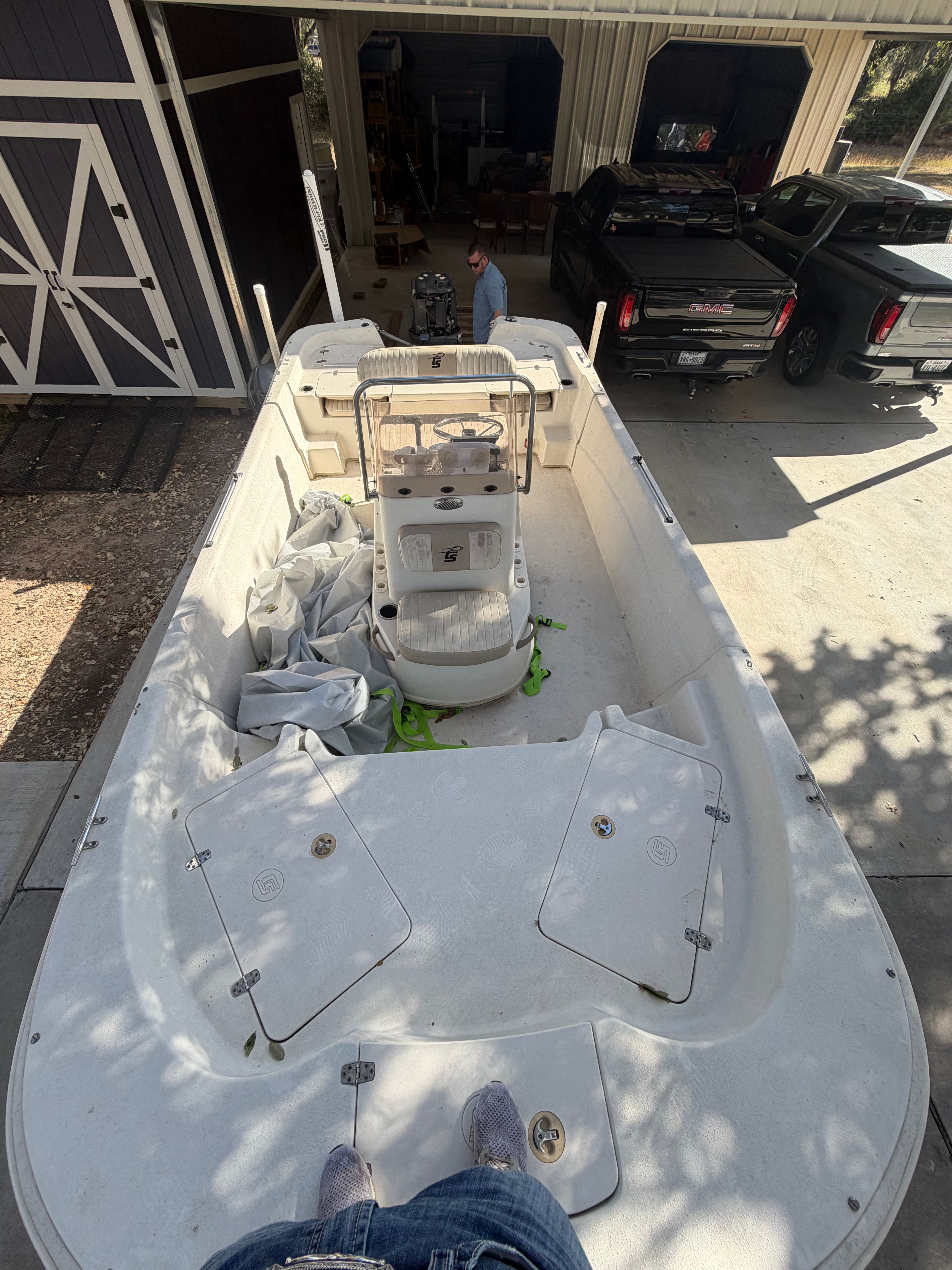A 2016 Carolina Skiff 178 DLV boat is on a trailer in a driveway.