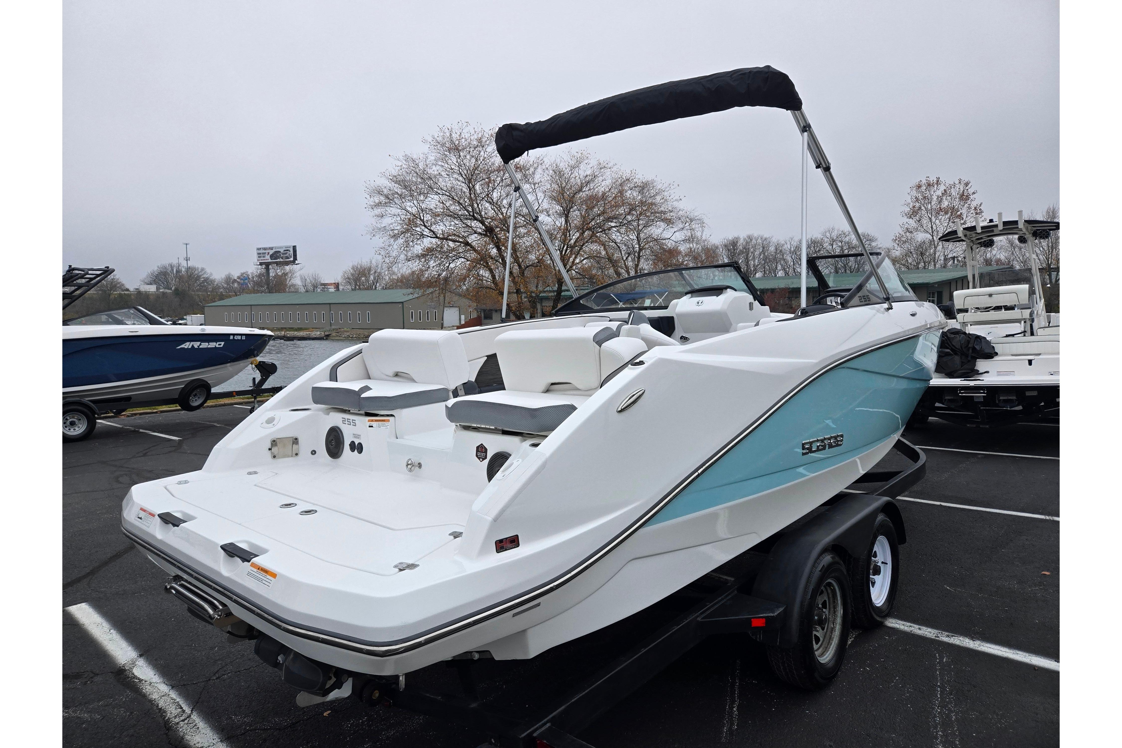 2021 Scarab 255 ID boat on trailer, white and blue design, parked outdoors.