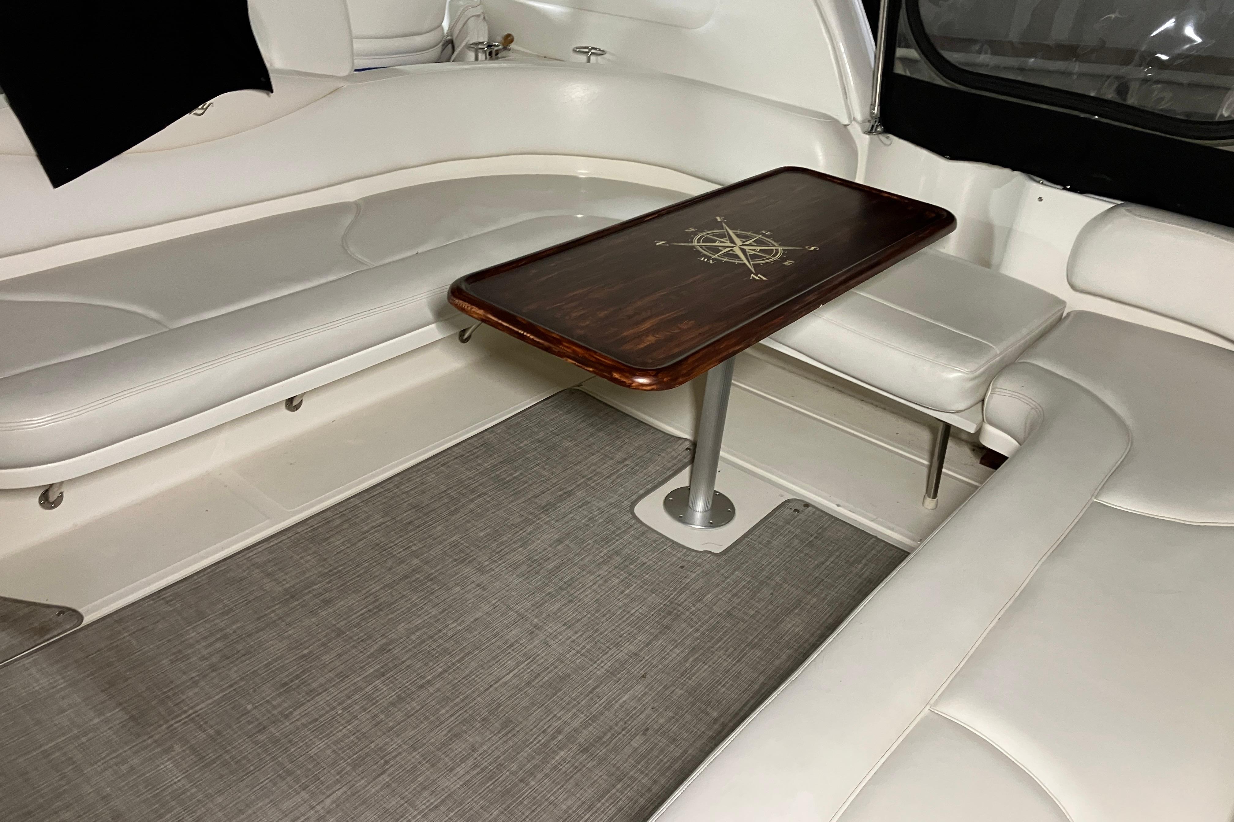 Interior of 2002 Sea Ray 410 Sundancer with white seating and wooden table.