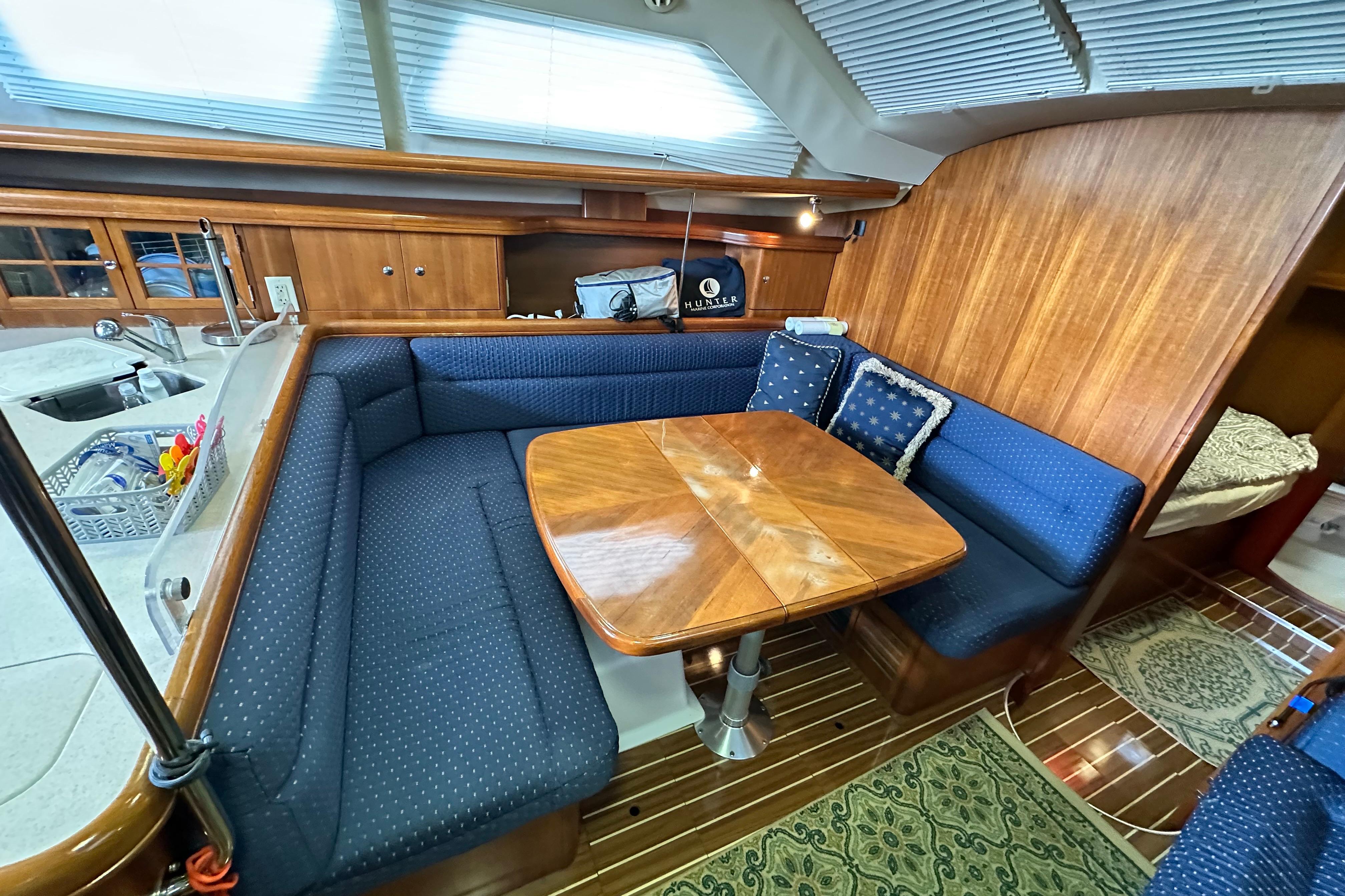 Interior of 2006 Hunter 41 Deck Salon with cozy seating and wooden table.