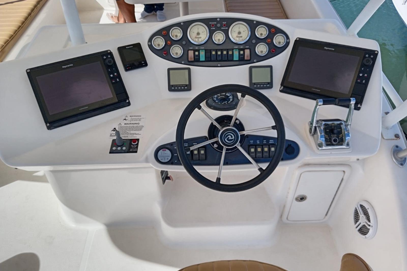 2005 Riviera 47 Open Flybridge Series II helm with dual screens and navigation controls.