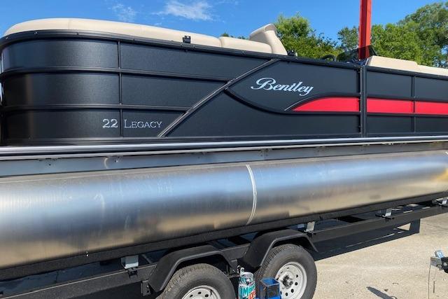 2026 Bentley Pontoons Legacy 223 Navigator on trailer, sleek black design with red accents.