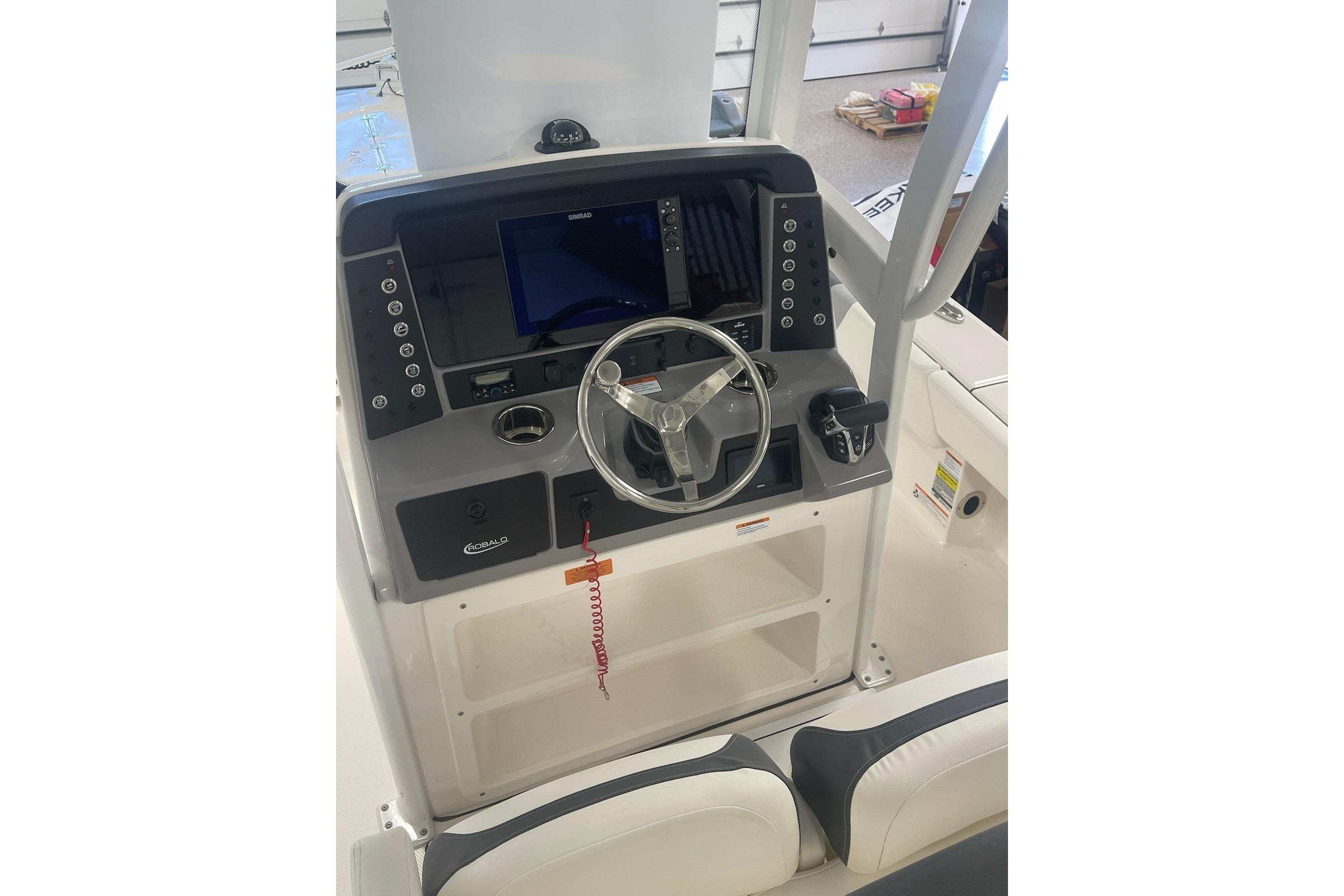 2024 Robalo 246 Cayman boat console with steering wheel and navigation display.