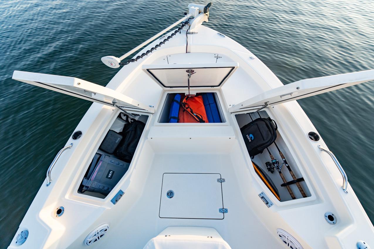 2026 Pathfinder 2200 TRS boat with open storage compartments on calm water.