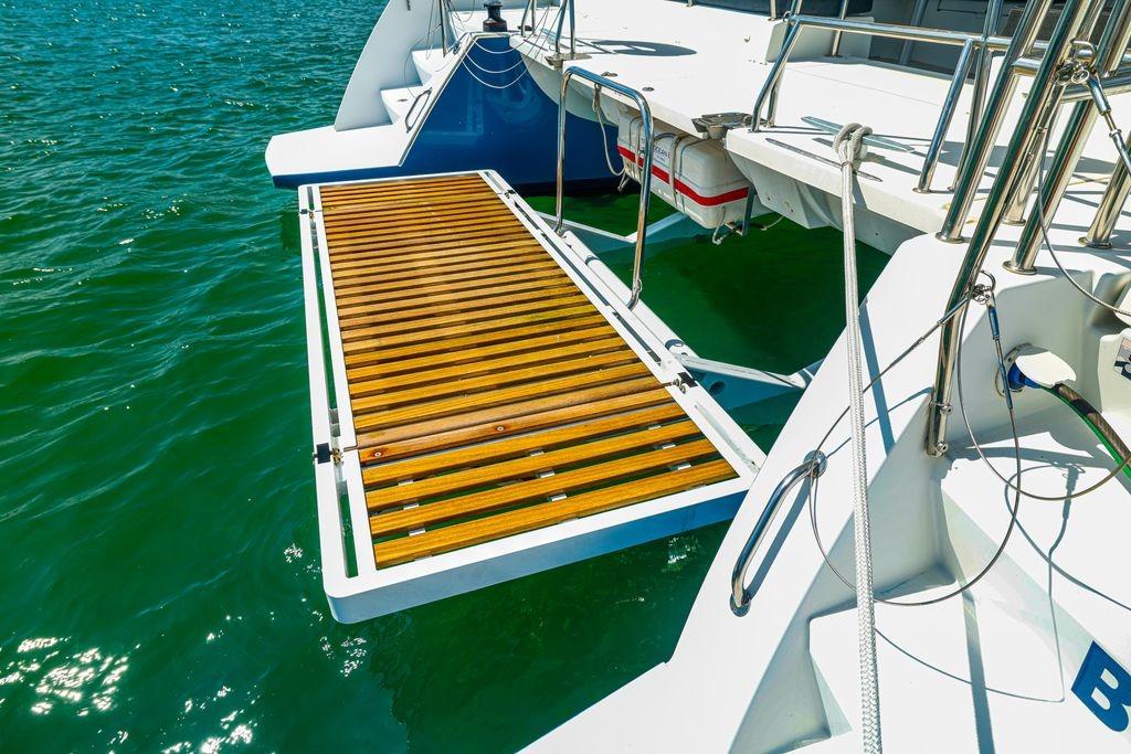 Catamaran Lagoon 450 F 2017 with wooden deck over turquoise water.