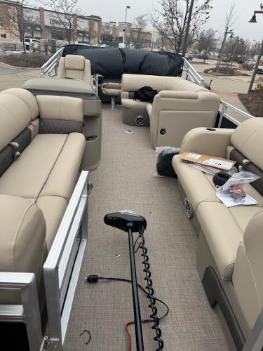 2025 Sun Tracker SportFish 22 DLX pontoon boat with beige seating and fishing equipment.