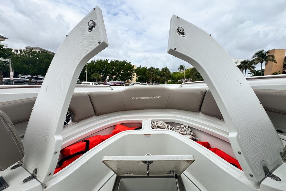 2023 Finseeker 220 CC boat interior with open storage compartments and safety gear.