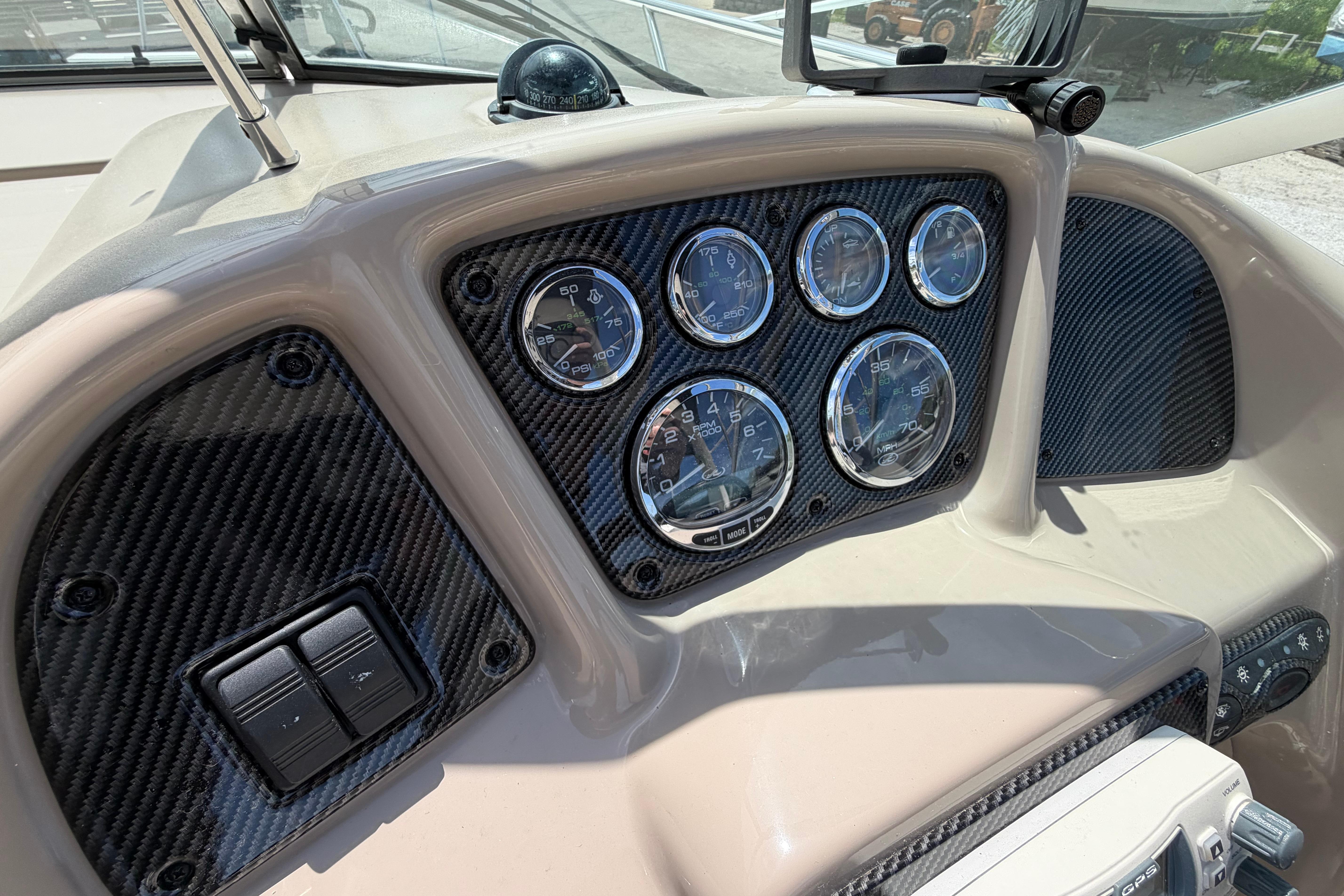 Dashboard of a 2004 Sea Ray Sundancer 260 boat with gauges and controls.