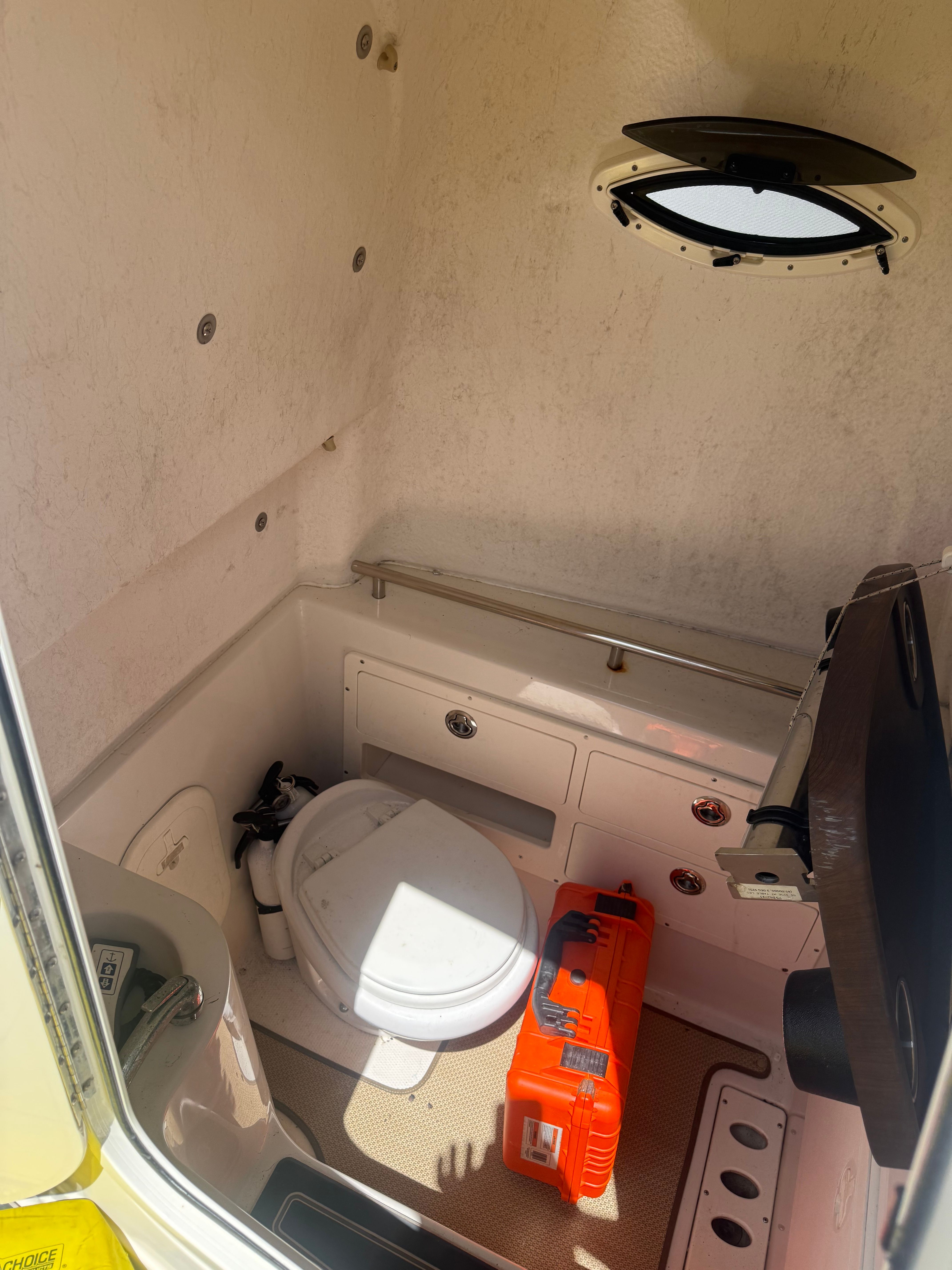 Interior of 2015 Sailfish 290 CC with toilet and storage.