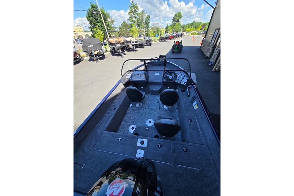 2026 Tracker Pro Guide V-175 WT boat interior with seating and steering wheel, parked outdoors.