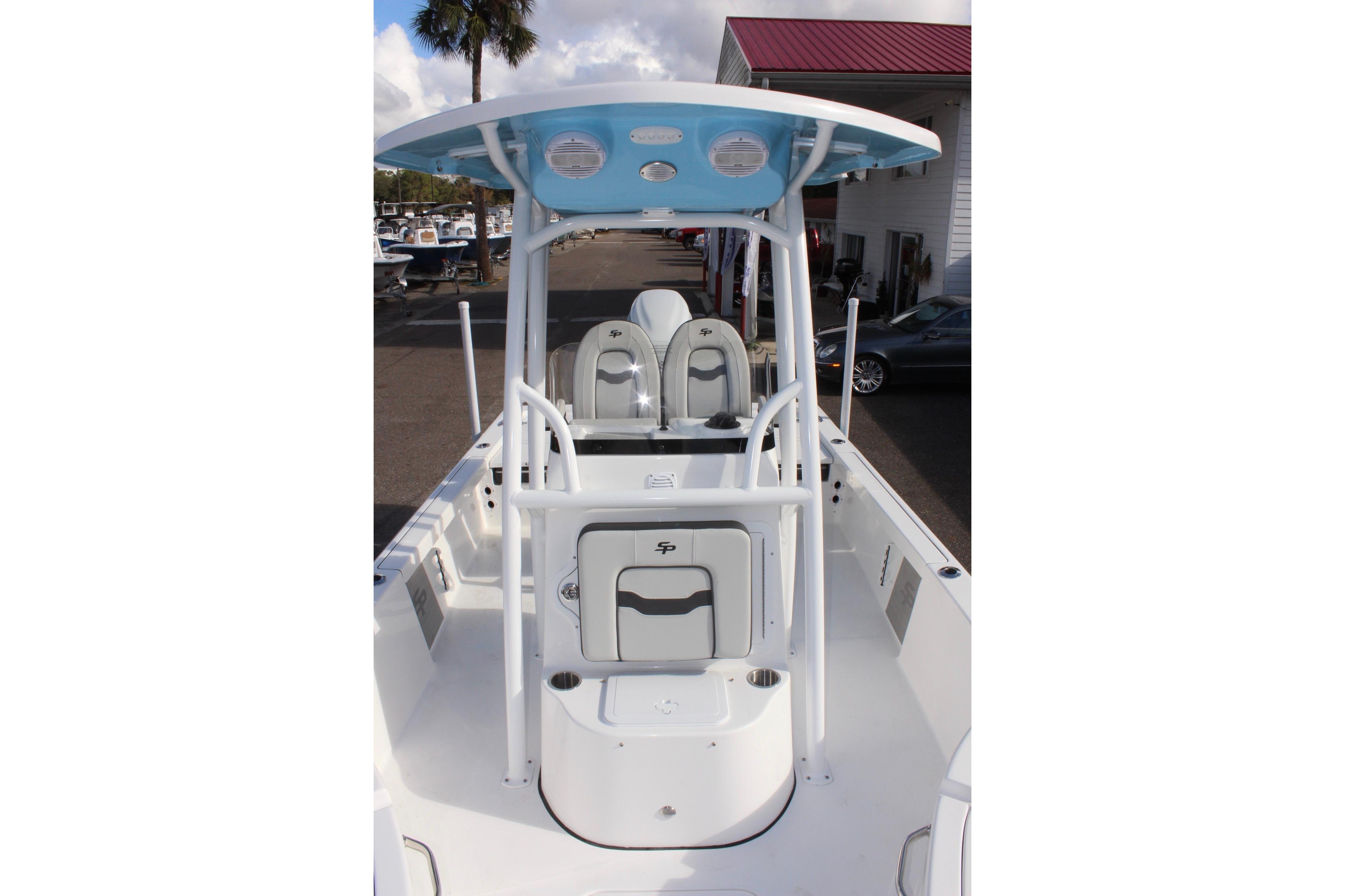 2025 Sea Pro 230 Bay boat interior with seating and T-top under clear sky.