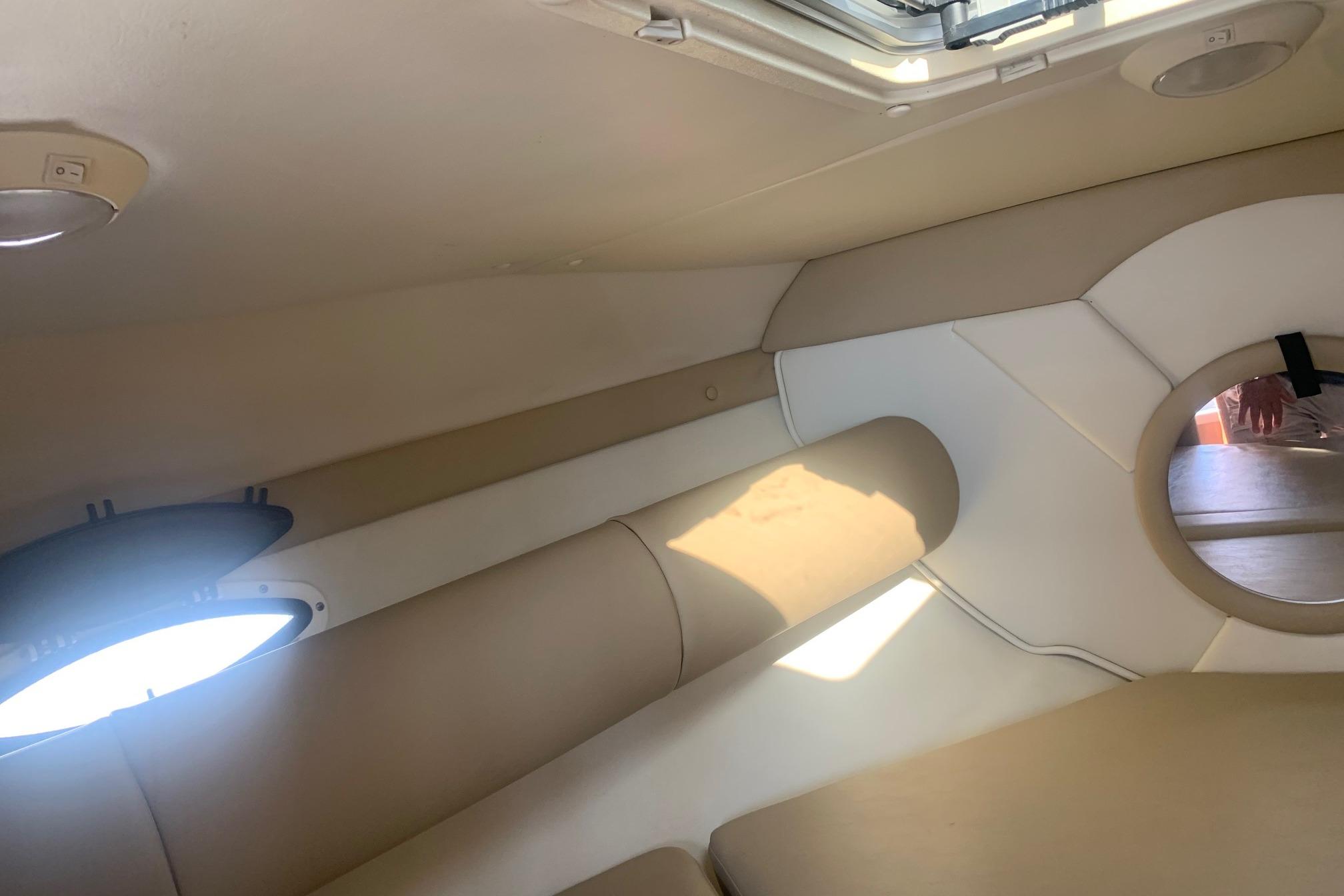 Interior of 2006 Rinker 282 Captiva Cuddy, featuring beige and white upholstery.