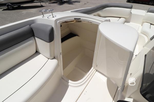2018 Bayliner 210 DB boat interior with open storage compartment and cushioned seating.