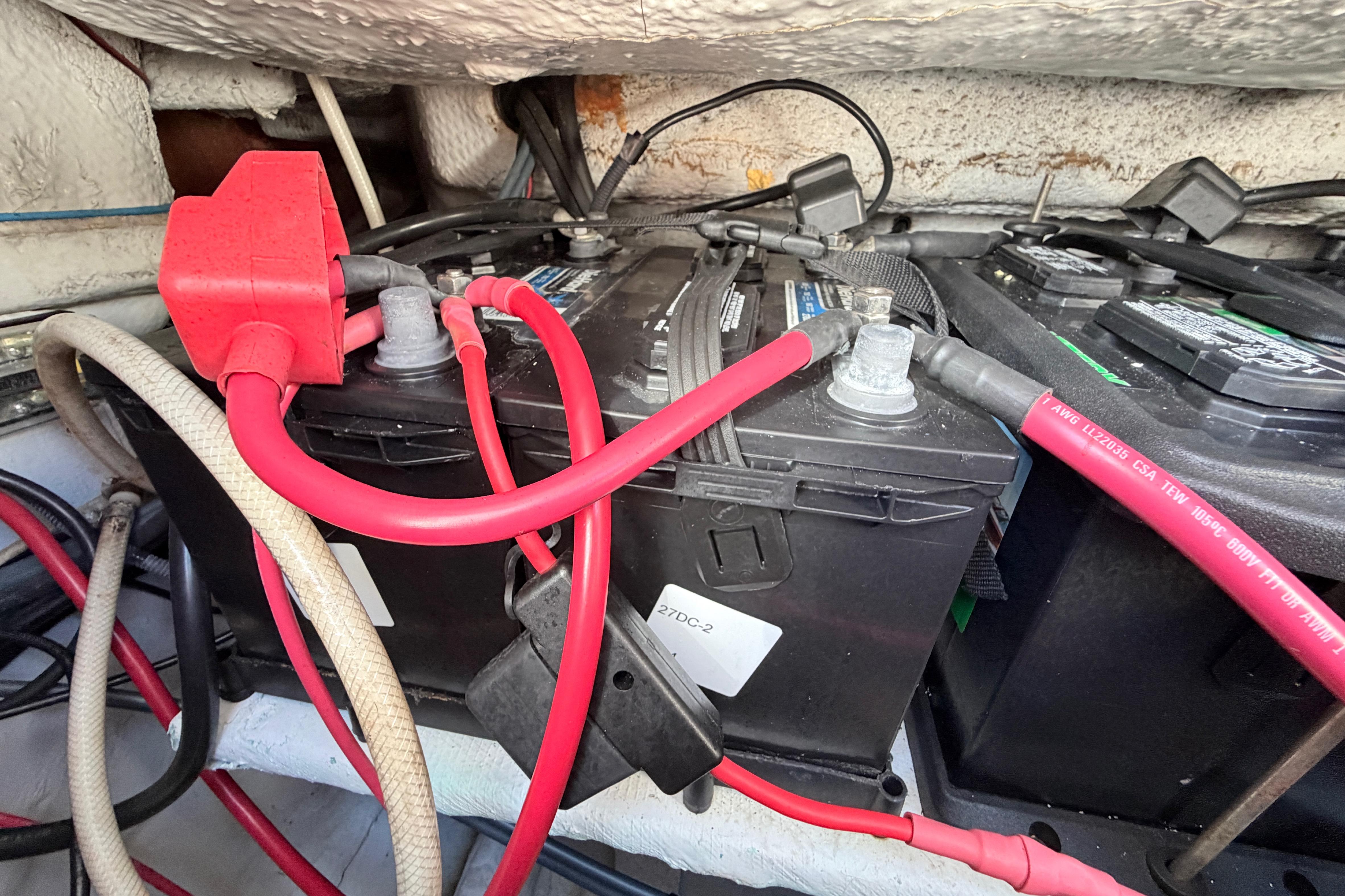 Battery compartment of 2006 Grady-White Sailfish 282 with red cables and connectors.