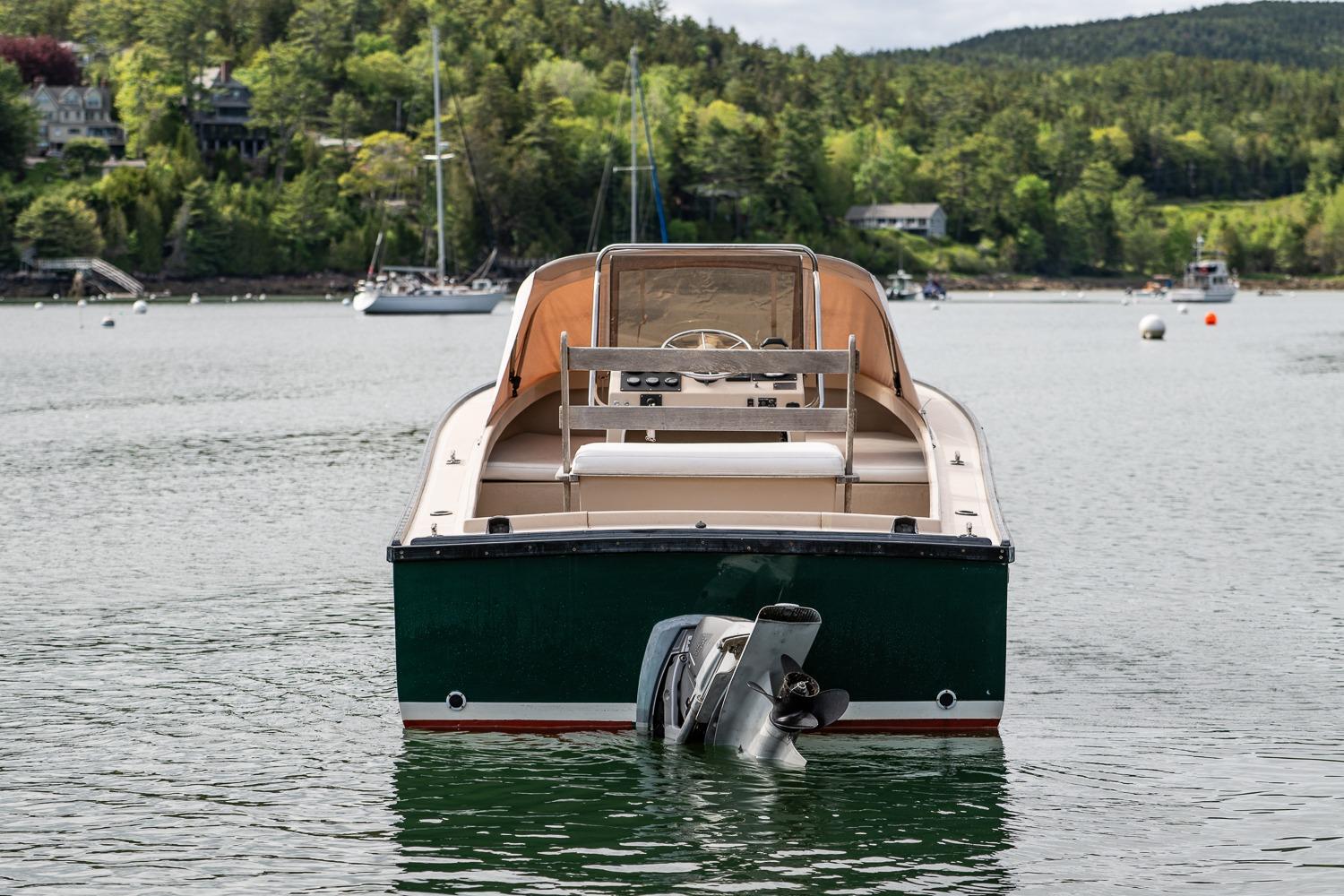 1989 Ellis 24 Open boat on calm water, surrounded by lush greenery.